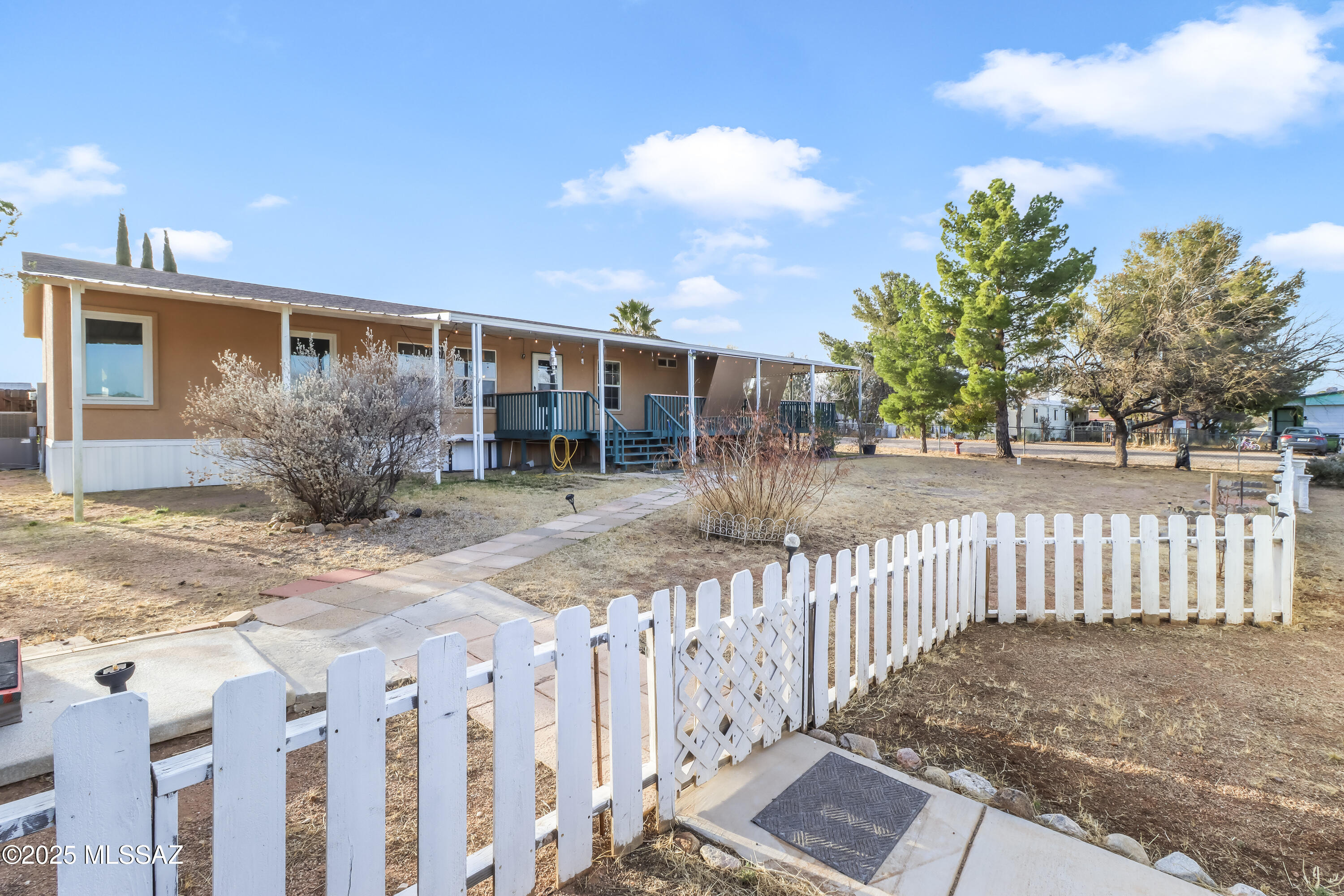 Range $249,900 to $259,900. Welcome to Mescal Lakes where you will find the Best of Benson in this 3 bedroom, 2 bath home with the perfect country wraparound deck and a beautiful lot. This property beams with pride of ownership, and feels like home the moment  you step inside. The warm and inviting formal living room opens into the kitchen and dining area. Off of the dining room, there is a separate family room with its own access to the deck. The master and guest bedrooms are on opposite ends of the home to maximize privacy. Improvements include energy-efficient Anderson windows, custom paint, newer flooring, and more. There is an enclosed porch off the kitchen waiting for your personal touch. Garage lot adjacent to house (124-15-047) available separately