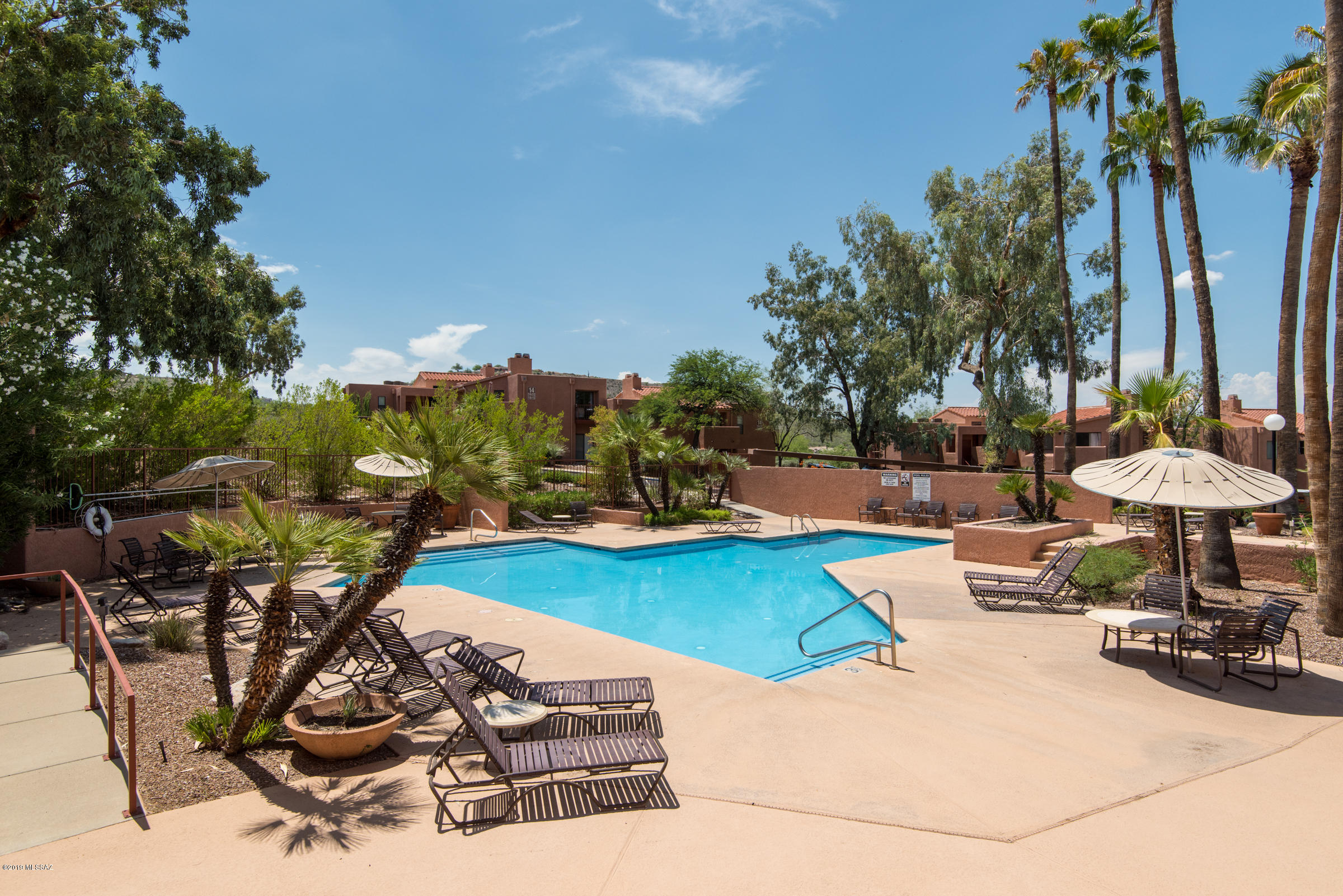 Private ground floor condo backing to natural desert landscaping in the gated Catalina Foothills community of Ventana Vista Condos.  This spacious Northern Tucson condo features an open floor plan with split bedroom layout, covered East facing patio, zoned heating & cooling, Murphy bed in guest bedroom, laminate wood flooring, kitchen with corian counters, wood burning fireplace, roomy master suite with walk-in closet, dual sinks in bathroom and access to a separate patio area and a popular location just South of Sabino Canyon Park.  The Ventana Vista Condominiums resort style amenities include a heated pool & 2 spas, enormous clubhouse with HOA office, pool table, tv & library,, exercise facility, tennis / pickle ball court, gas bbq spread throughout community and well maintained grounds.