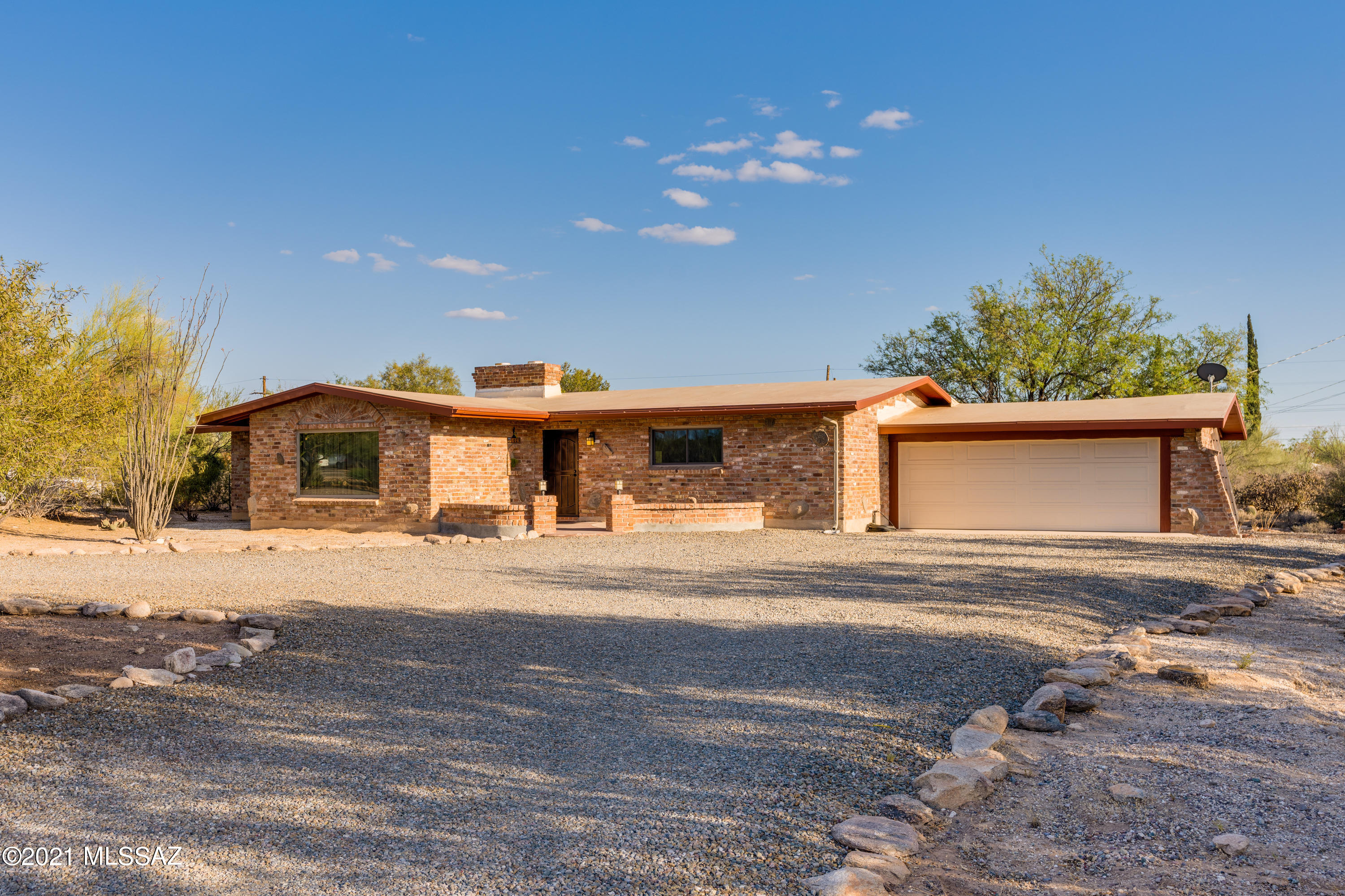 Absolutely charming brick ranch in desirable Northwest Tucson. Maintained & upgraded over the years by the original owners. Remodeled kitchen features custom cabinetry, granite tops, undermount steel farm sink & stainless steel appliances. Recently installed wood-look ceramic tile in all living areas & upgraded carpet & pad in bedrooms. Master bath has quartz vanity & custom tile shower surround. Entire home has dual pane windows & energy saving solar panels (leased). Generous storage with large walk-in pantry, interior laundry room & 2 car garage with additional storage room. Home is situated on a quiet & serene .84 acre lot with mountain views just steps away from Tohono Chul Park  & all the amenities that NW Tucson has to offer.