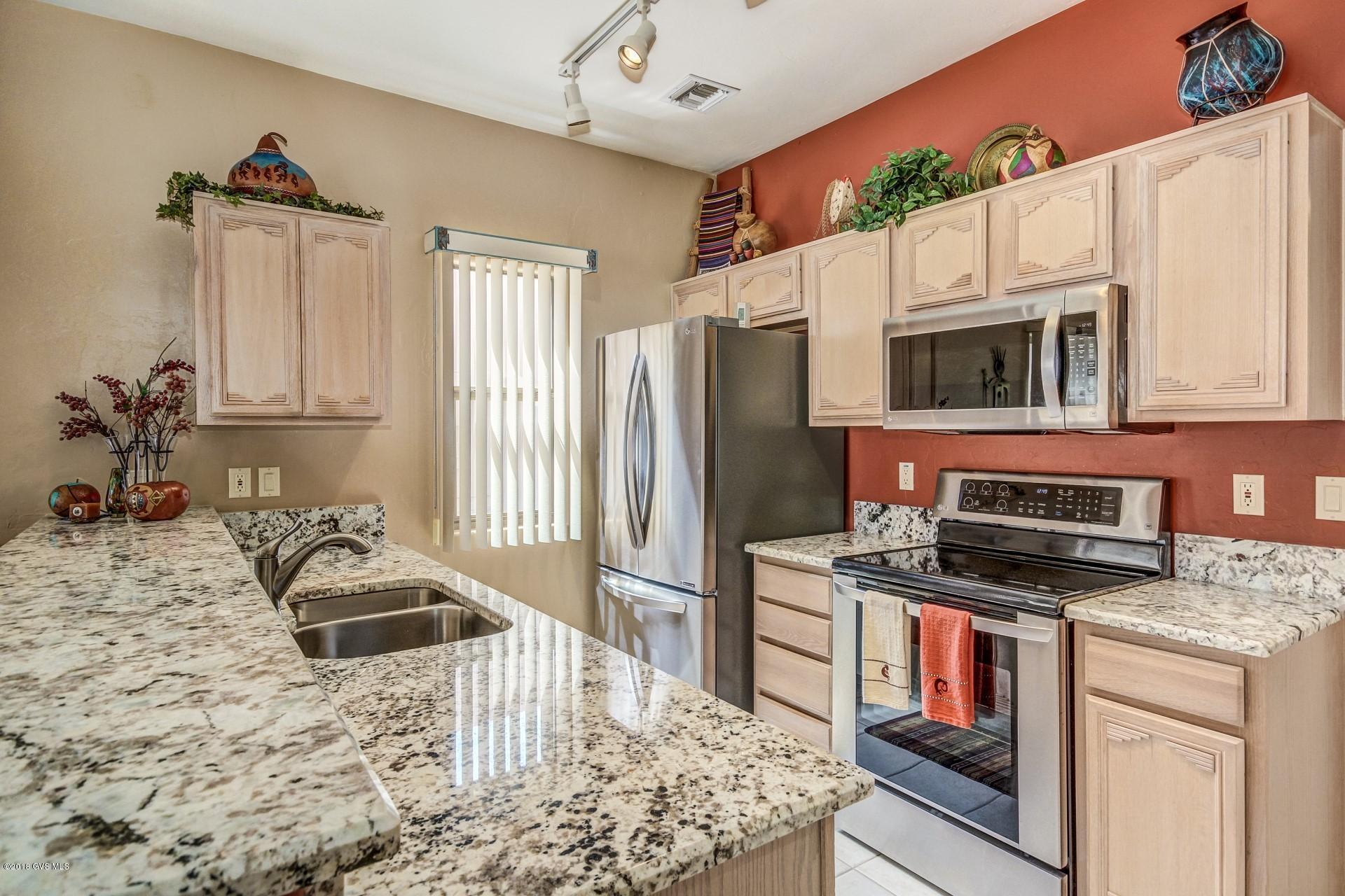This fantastic San Miguel model is located in the heart of the Santa Rita Springs gated community. With 2 bedrooms, 2 bathrooms and a 1 1/2 car garage, this light and bright 1258 sq. ft. townhome shows pride of ownership throughout. Enjoy the recently updated kitchen with granite countertops and stainless steel appliances. The split floor plan offers privacy for guests, with tile flooring throughout and a convenient pocket office. Updates include: heat pump in 2016, washer and dryer in 2015 and water heater in 2014. Enjoy the outdoors in the charming southeast facing backyard with a peek-a-boo mountain view. . The following items items covey with property: Living room sectional sofa, 2 side tables and 1 chair. Guest Bedroom furniture excluding art work. This recently updated and  carefully maintained home is just a few blocks away from the Green Valley Recreation Center. Age restricted 55+. GVR Membership