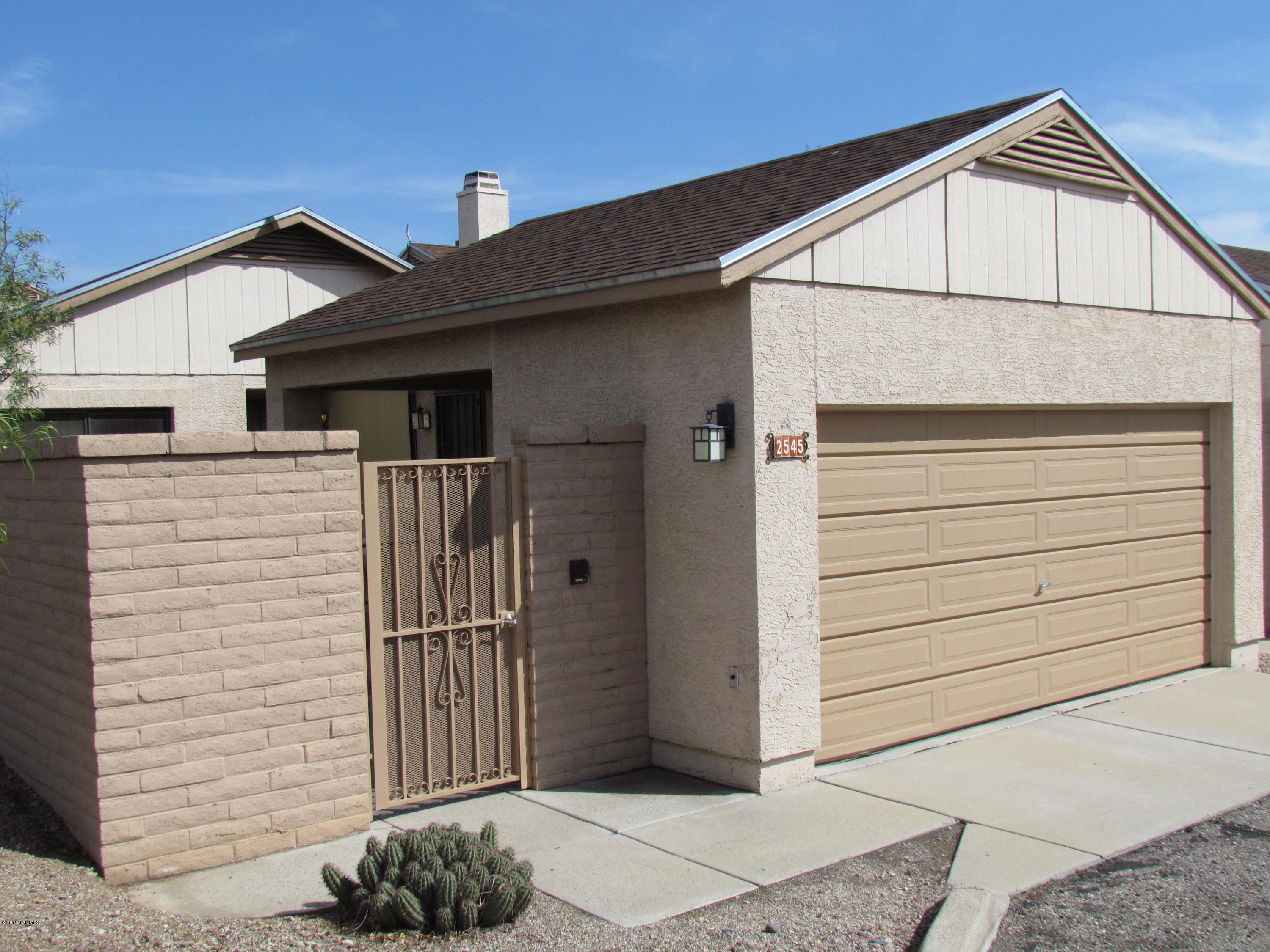 Beautiful Gated Community in a convenient westside location near U of A, Pima CC, shopping and restaurants. Gorgeous Premium Lot holds this Very Private Stand Alone end unit overlooking the Santa Cruz and nature. Home is beautiful with designer paint colors, wood laminate flooring with all new lighting and plumbing fixtures and Stainless Steel Appliances. Carport has storage/work room. Lovely private patios- both at entry and off master waiting for your potted garden or personal spa. Very relaxed living with a community pool and spa. Bring your clients they won't want to leave. NO WORRIES- OLD REPUBLIC HOME WARRANTY has you covered!