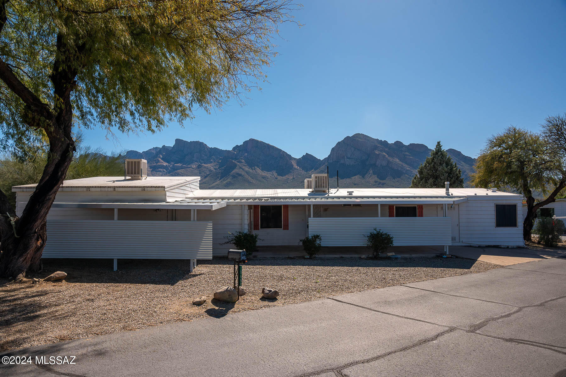 55+ community located in the heart of Oro Valley, AZ, where each lot is owned, not leased! Fabulous Catalina Mtn views from the sunny back patio! Huge living room & lovely kitchen w/beautiful cabinets, bkfast bar. 480 s/f slab addition built in 1989, noted as Br 3 on the floor plan. Water plumbed to one of the closets in that Br which served as a darkroom. Spacious Primary ste w/updated bath, soaking tub & sep shower. Br 2 has private bath & shares bath entry from the hall, as well. Corner dbl lot give you elbow room, & lots of parking w/ one, 2 car carport & one, single car carport, both newly rebuilt. Amazing storage room could be used for many purposes. Gorgeous clubhouse w/performance stage, library, card room, huge pool, mini golf, bocce, shuffleboard, Huge walk scores to services!