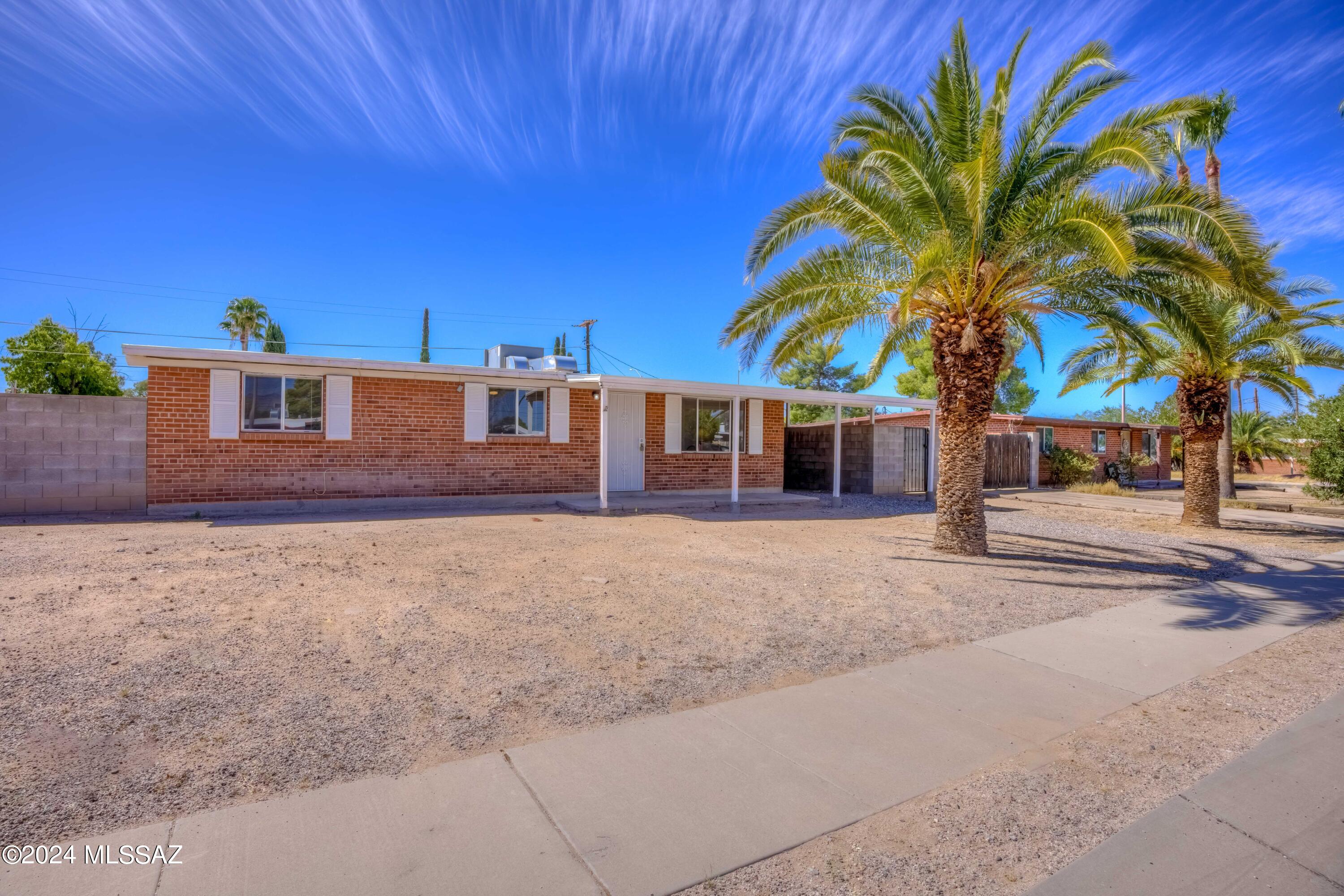 Brick home, 3 bedroom 2 bath and move in ready.  New paint and new carpet (bedrooms only) and newly cleaned /polished Saltillo tile in the main spaces. Enormous lot and large storage/workshop outbuilding. Carport parking and easy care yards.  Back patio for entertaining. Single level and no stairs. North/South exposure helps with those summer utility bills. New window blinds throughout. NO HOA and plenty of room for toys and parking. Close to shopping, entertainment, bus lines and schools. Great price for a move in ready home! Hurry.
