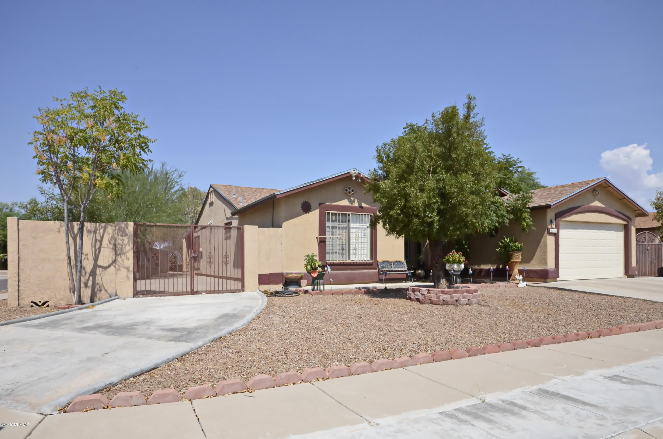 Beautifully designed & impeccably maintained, this 5 BR, 2 BA house sits in a corner lot at Oakmore at Midvale! This home feels much bigger than its 2,143 SF & the split floor plan permits plenty of privacy. The bedrooms are large & nicely appointed with ceiling fans. The gourmet kitchen boasts granite counter tops, stylish cabinetry & lot of storage. The huge covered porch allows for plenty of room for entertaining, and the large back yard could easily accommodate a pool. There are gates on both sides of the house, that open to uncovered patios with pavers, with tons of room for an RV, boat or other toys. Wood shutters & security bars on all windows, as well as screen doors. Conveniently close to shopping, schools, the Santa Cruz River & bike path, this elegant home has it all. MUST SEE! Agents and their clients are asked to please wear masks when visiting this property. Thank you!