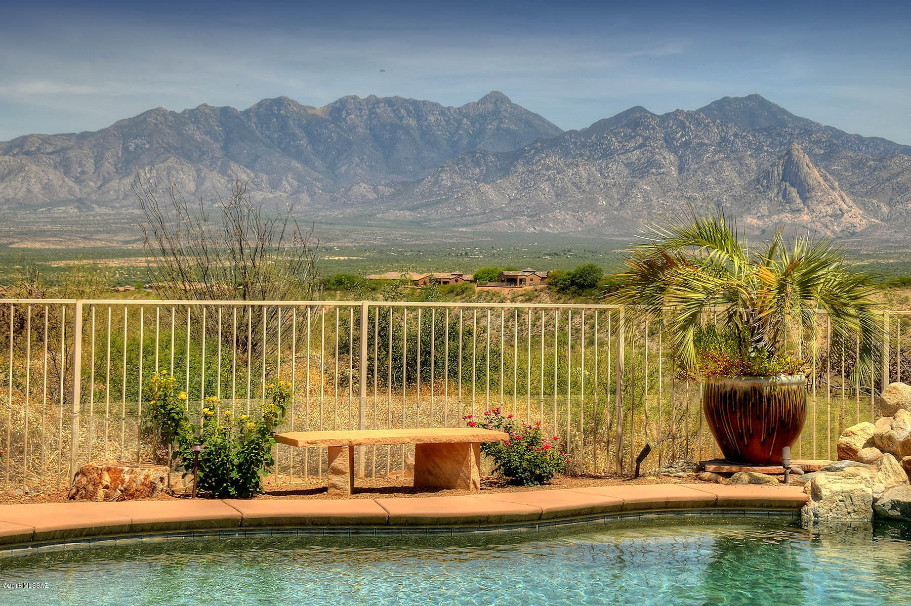 Boasting one of the most stunning lots in Green Valley, this gorgeous home sits high on a hill overlooking the Canoa Ranch Golf Course and the breathtaking Santa Rita Mountains.  Completely private, there is nothing to see but mountains from both the inside and outside living areas of this beautiful home.  Almost 2500 sq ft includes 3 beds, 2.5 baths, large den, living/dining room, and family room off of kitchen.  Windows in all main living areas, including the master bedroom, showcase the capitivating views and custom wooden doors accent all entryways.  The kitchen and family room, although absolutely elegant, are also warm and inviting.  Rustic rock walls and rough edged carmel/brown granite counters pair with richly toned custom cabinets and a roaring corner beehive fireplace. A torched copper sheet and hood frame the speciality gas stove, and a huge granite island invites guests to gather.  Custom built ins in the open den add sophistication as well as utility.  The master suite is spacious and features a bump out seating area surrounded by windows overlooking the mountains.  You will spend most of your leisure time on the back patio where the sparkling pool beckons and an outdoor kitchen and kiva fireplace take entertaining to the next level.  You will be awe-struck each time you step up to your hot tub and gaze at the drop off into the arroyo and the endless mountains beyond.  With brand new dual zoned heating and cooling units and an oversized 3 car garage, you will surely call this your DREAM HOME.
