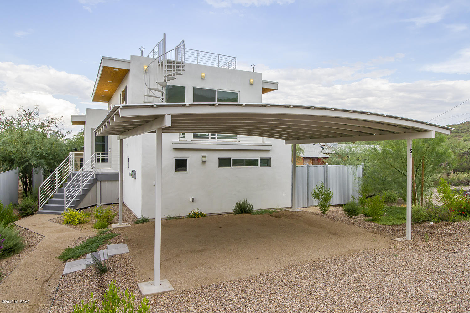 Brand new, modern design just west of Downtown, located just a few blocks from the Mercado and at the base of Sentinel Peak.  This spectacular home was the vision of it's architect/owner, and utilizes design elements comparable to high-end urban lofts.  Multiple terraces take full advantage of the impressive views of Downtown and A Mountain, and there's even a roof top deck with stair access.  This home is a model of efficiency, and features zoned mini-split units for heating and cooling, as well as an owned PV solar array.  Possible $4000 solar tax credit may be available to purchaser, plus 5000 in banked KWH.  Custom-built carport utilizes a graceful metal arch for 2 cars, and there's even a pre-wired charge port for an EV.  Lower level features a large den in lieu of a third bedroom.