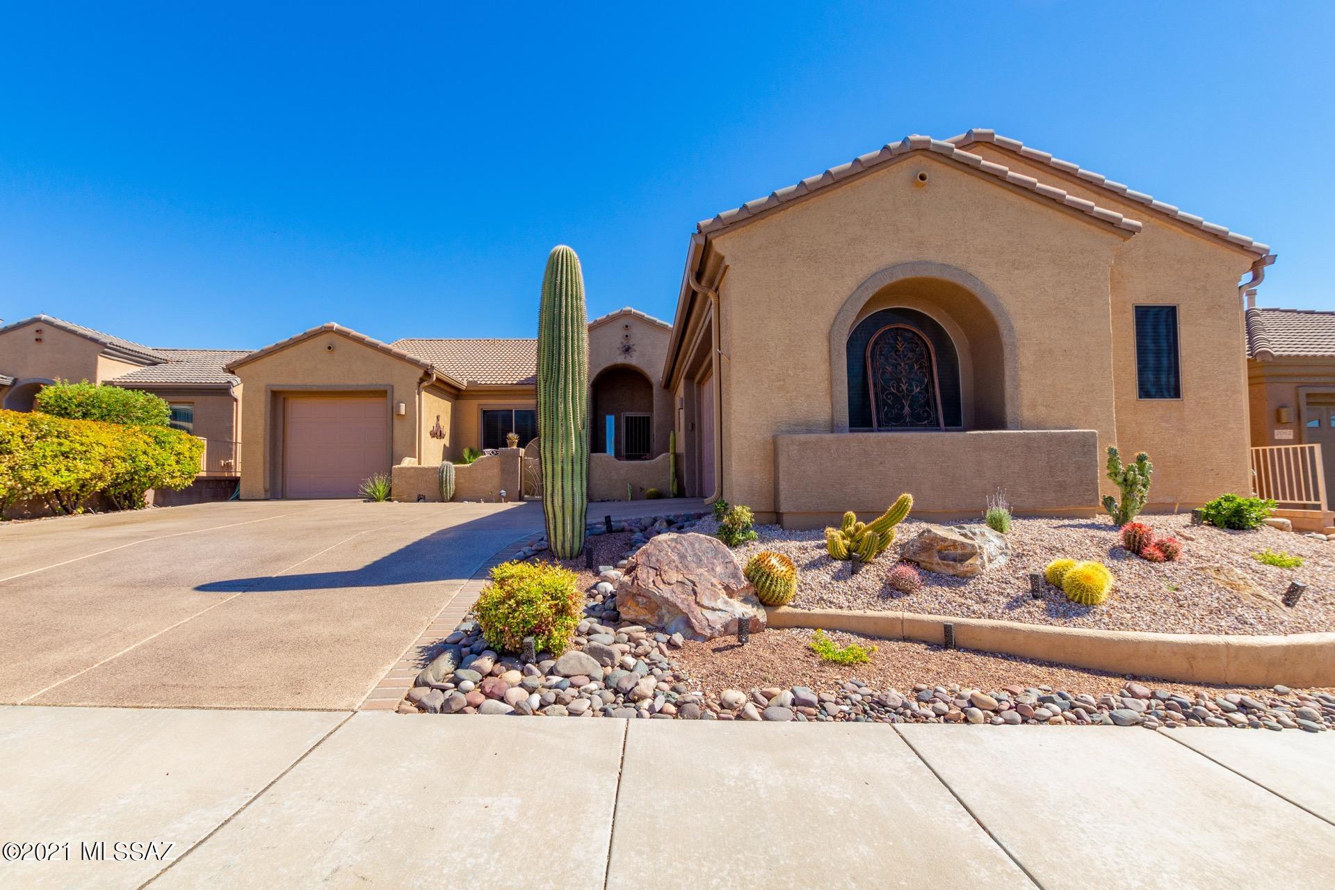 Welcome to the Gated Community of Canoa Ranch! Spacious great room floor plan w/a gated courtyard entry & 3 car garage.  Charming corner fireplace, plantation shutters, ceiling fans, custom palette, beautiful tile floors, & upgraded lighting. Private den offers built-in bookshelves, desk, & cabinets. Stunning chef's kitchen features a center island, granite counters, tile backsplash, SS appliances, & plethora of handsome wood cabinetry. Formal dining room is perfect for entertaining. Gorgeous wood floors in all the right places, ample closets, large bedrooms, & pristine baths. Master retreat offers patio access, private en suite w/dual sink, & a walk-in closet. Large laundry room w/storage cabinets. Fantastic screen in patio w/pavers & Mountain views. Enjoy the hot tub & built-in BBQ! And Owner has replaced original HVAC system with the premium high efficiency and quiet Daikin system. Carpeting replaced with high-end, easy to clean vinyl plank; interior and garages re-painted, toilets replaced with Toto single piece models; added gladiator storage boards to mount bins and accessories; replaced wrought iron gate and added railing on shared wall, and epoxy coated driveway. All improvements valued at over $40k.