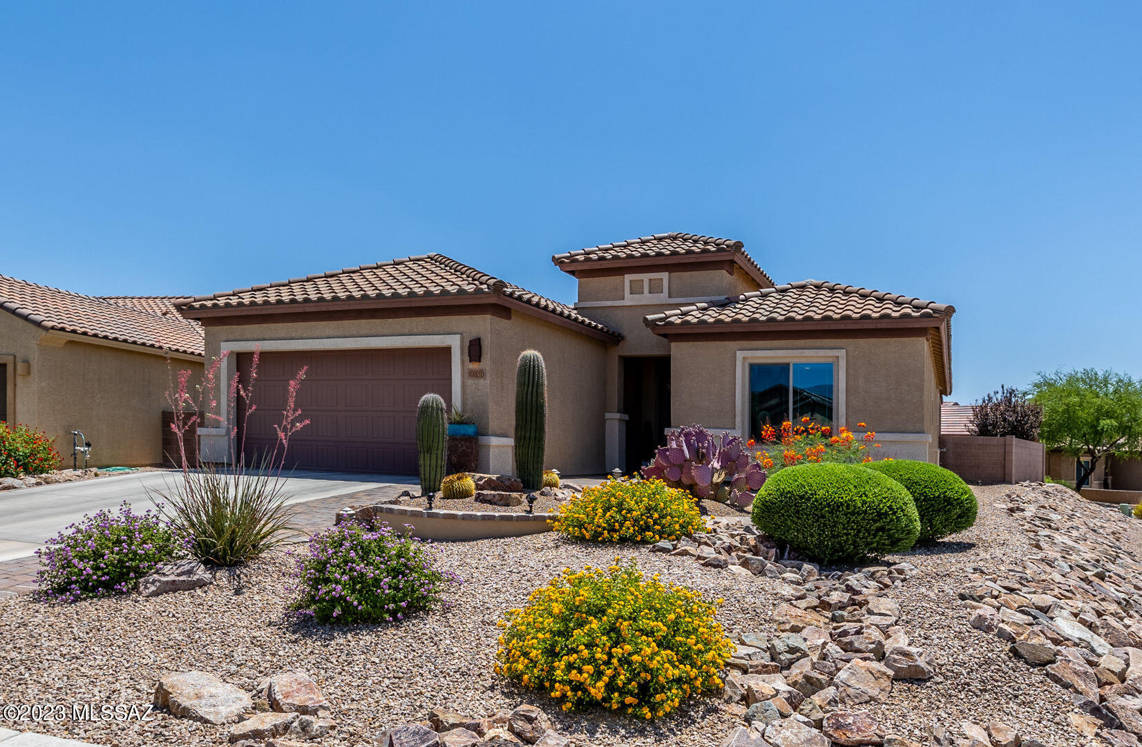 Don't miss out on this beautiful 1 owner home in the active, 55+, Rancho del Lago gated community. Located on a corner lot in a cul-de-sac, this 2 bed, 2.5 bath, 2 car garage home boasts a den, an en-suite bathroom, a newer water softener, a tankless water heater for unlimited hot water & has a 22 ft. extended garage space for your new golf cart! The large windows let in plenty of natural light & provide almost panoramic views of the Rincon & Santa Rita mountains. The backyard is designed for ultimate relaxation. There is low care landscaping with native desert plants, a gas fire pit, a covered patio that extends the length of the home plus block pavers and decorative gravel. At the end of a long day picture yourself sitting back and watching the city come to life or the monsoons roll in!