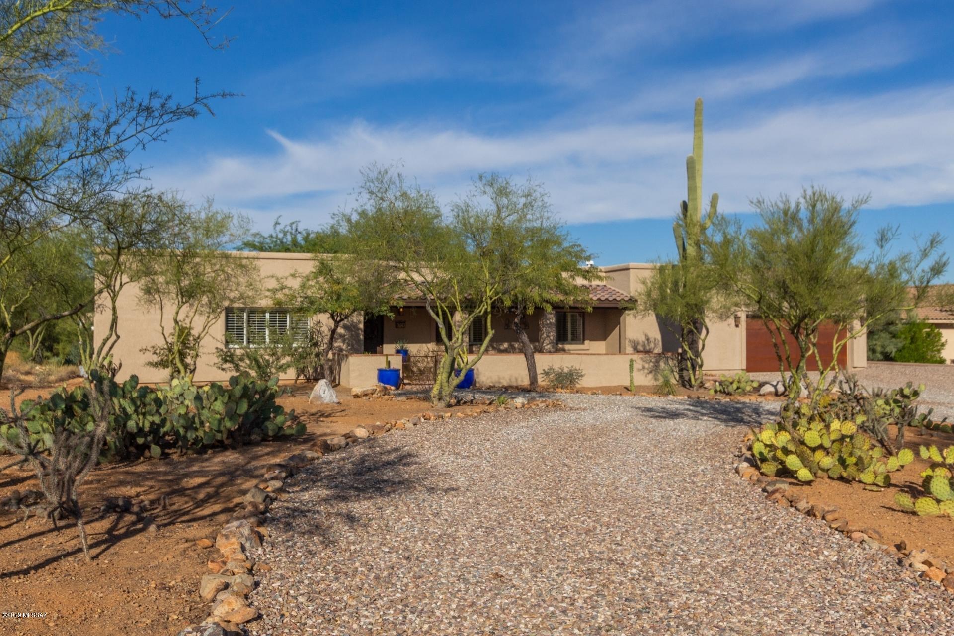 Tucson gem near Ina and Silverbell with views, shade trees, fireplace and oversized master! This spacious 3 bedroom, 2 bath home is 2,093 square feet on a serene 1.12 acres of horse property. This home has been upgraded with a new A/C unit, gas water heater, granite kitchen countertops, tile backsplash, all new kitchen appliances, interior/exterior paint, light fixtures, metal fascia with oversized gutters, and roof restoration! The home is complete with a fully finished and insulated, oversized (840 sq ft) dream garage with +220v power, ventilation, workbench and cabinets! Quiet subdivision with no HOA and access to hiking in Saguaro National Forest. Stunning sunrise, sunset and mountain views from both sides! Space for RV parking, outbuildings and a pool!