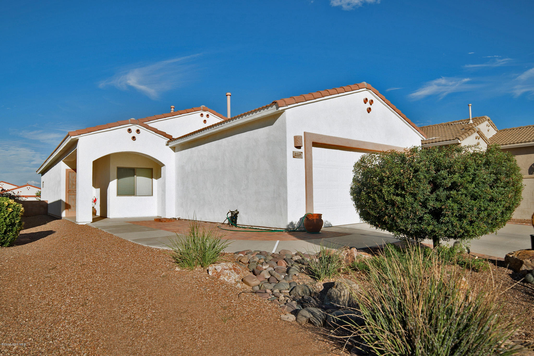 PRICED BELOW RECENT APPRAISAL. Crisp and manicured landscaping greet you with an arched front walkway. A brilliant color scheme utilizing hues of the Southwest, large floor tile and an open living space will inspire your visit to this well cared for home. Notice the kitchen's expansive counter top incorporating a convenient prep-cook sink and traditional white appliances contrasting the wood grain cabinetry. Add in the roomy dining area and this becomes the hub of this great room floor plan. Dramatic elegant colors continue throughout the peaceful living room with its setting designed perfectly for quiet conversation. Accent walls offer special acclaim as you walk from the master bedroom through a tall colorful archway into the bath with its twin sinks and extended seated walk-in  shower. Stretch out on the back patio with its generous brick paver deck and easy maintenance cactus island with luscious common area backdrop.