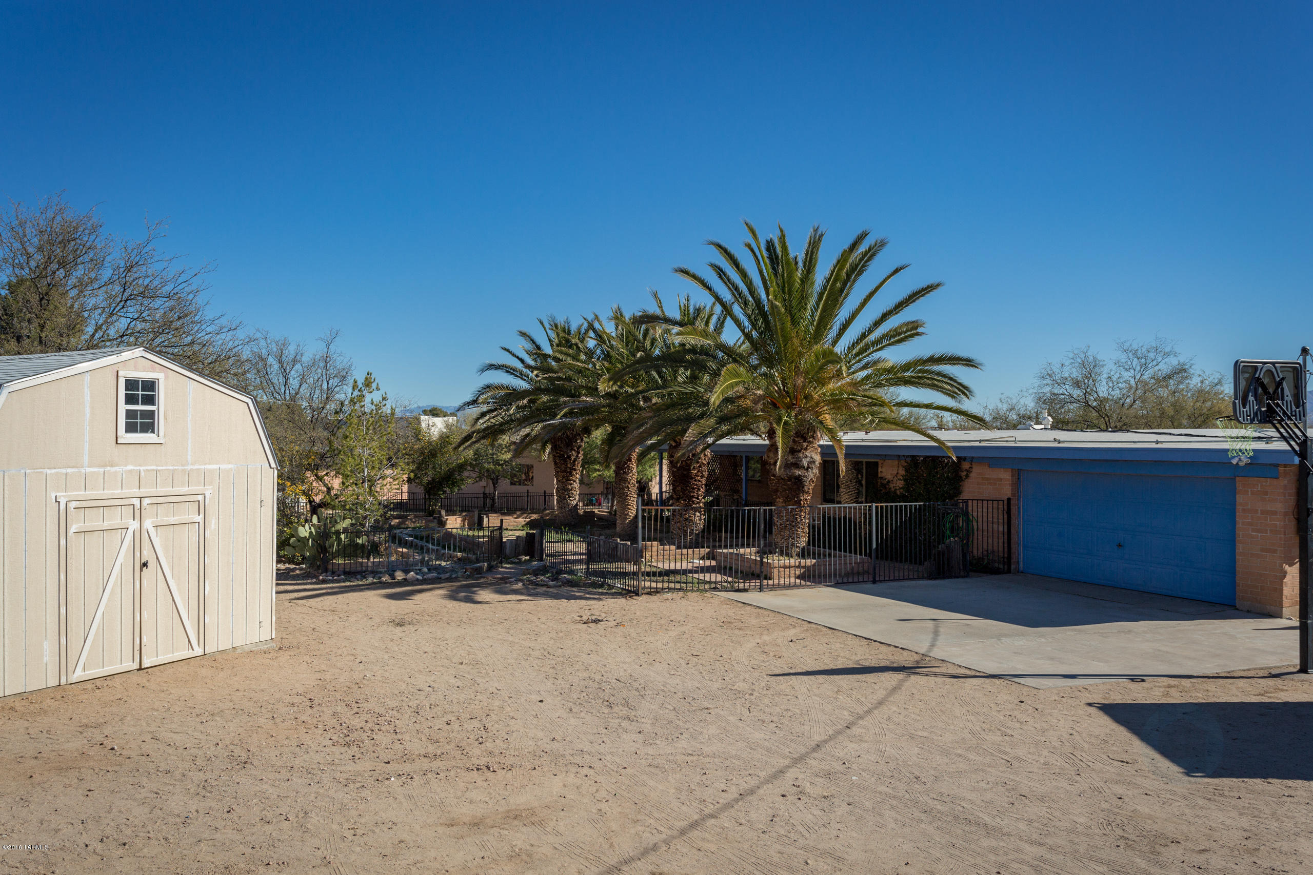 SELLER SHALL COUNTER OR ACCEPT OFFERS BETWEEN $275,000-299,000. Two homes on one large property! The entire 1.3 acres is surrounded by a 5ft block wall; solar electric entry gate to property;zoned for horses;has chicken/coop & tac room;barn;work shed; storage shed;basketball court;separate walled off back yard for main house and separate front and back yard for the newly built guest house which has its own carport. New central A/C, heat, water heater in both houses. Main house has a huge kitchen, dinning room, family room, living room, 2 remodeled baths, new tile throughout; view of Santa Rita Mountains from kitchen window; Many gardens throughout property; great sunset views; room to park RV and or have goats and horses. VERY PRIVATE AND SECURE. Just a walk to Park with Soccer/Baseball fields, Basketball, Dog Park, Skate Park, etc. and Walmart Center.