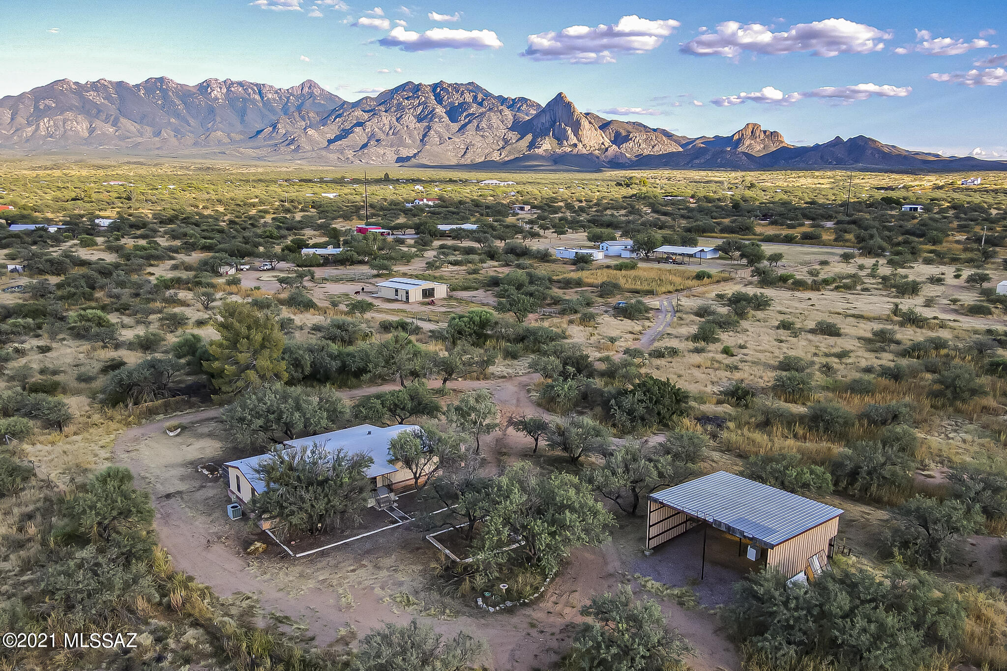 Escape to Country Living in this 3 BR, 2 BA  remodeled Manufactured home on 3.20 fenced acres.  There is also a large building that could be used as a haybarn, RV storage...  Enjoy beautiful Santa Rita mnt views with large mature Mesquite Trees from the covered back patio.  Pet lovers or gardeners can appreciate the large covered fenced outside area.   Water well has 5 shares with water well agreement.  All inside plumbing has been replaced along with a new roof.  Recently painted with with new carpet.   NO HOA and is horse property.