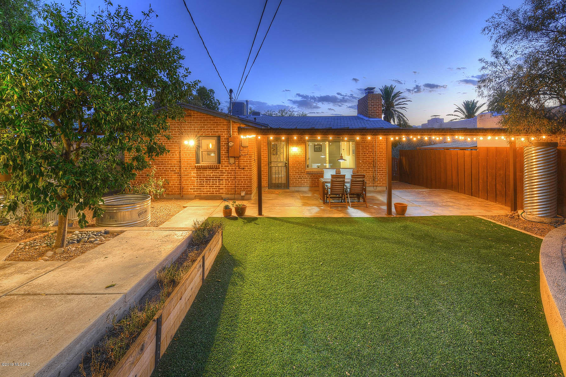 Sam Hughes 1950's double brick bungalow, newer dual pane windows, renovated kitchen with lots of storage, stainless steel appliances, breakfast bar. Newer bathrooms with flat panel cabinetry, scored & colored concrete floors, Fireplace in living room, 3rd bedroom used as den, Large covered patio, meticulously &  thoughtfully landscaped, turf, garden beds, Master bedroom has private bathroom.  Separate office not included in sq footage, separate storage, custom metal gates & fences, newer AC. A contributor to the national historic district for owner occupied home owners. Off street parking!
