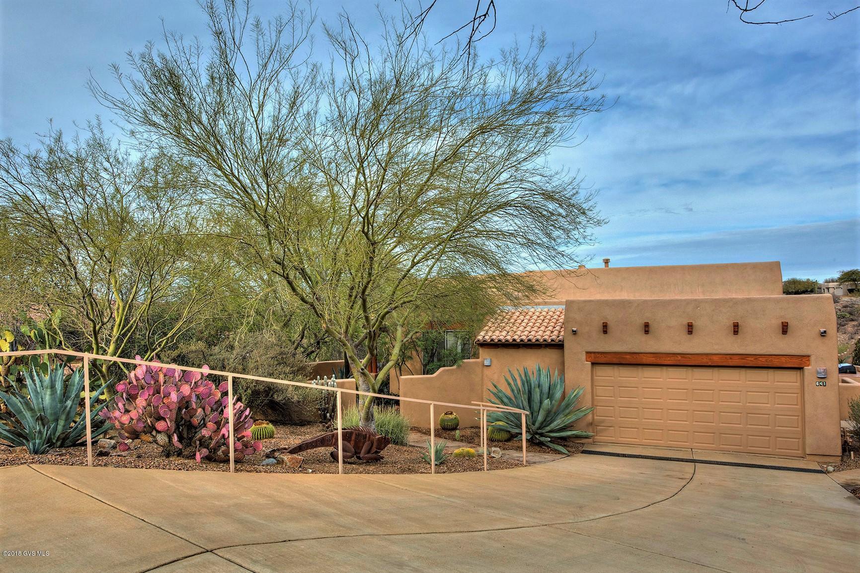 Beautifully appointed Santa Fe style home in Madera Reserve exudes pride of ownership. Tranquil desert setting & open space provide a rural feel & sense of total privacy w/friendly neighbors close by. Charming palo verde lined courtyard leads to a stunning solid wood front door. Foyer opens to a spacious, airy great room w/wood grain porcelain tile, 12' ceilings, beehive FP, and large windows showcasing sweeping desert views. Vigas, wood beams, pony walls & niches. French doors to patio overlook a lush arroyo, mountains & ever changing skies. Unsurpassed sun & moonrise watching! Den w/murphy bed. Formal DR. 2 MBRs; 1 w/dbl vanities, jetted tub & walk in shwr. Generous tiled Kit w/island, pantry, pull outs, appliance garages & lots of natural light. Outdoor gas BBQ. Powder room & laundry  off kitchen. Oversized 2 car garage has epoxy coated floor, storage cabinets, work area w/ work bench.