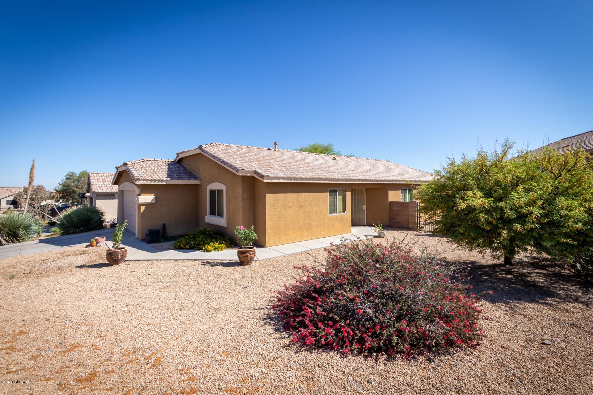 Beautiful move in ready home available in desirable Santa Rita Ranch. Incredible southeast Tucson community, located within easy reach of the I-10 and within the award winning Vail School District. 3 bed, 2 bath PLUS DEN with a desirable open concept floor plan, perfect for gathering friends and family. Vaulted ceilings, neutral paint tones, soft natural lighting throughout and wired for a sound system. Inviting kitchen. Elegant french doors open to the spacious den. Bedrooms are generously sized and the master includes a private en-suite with dual sinks. The secluded low maintenance backyard borders Santa Rita Ranch Park and offers a partially covered paver patio, a perfect spot to entertain or relax after a long day. This gem is a must see. Call to schedule your showing today.