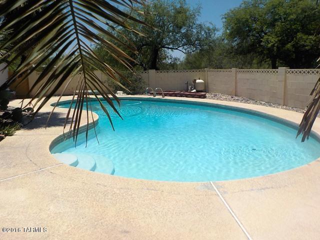 This charming 4 bedroom, 2 bath home is located in the Catalina Foothills School District. The great room boasts a beautiful beehive fireplace and a sparkling swimming pool to enjoy which was recently renovated and monthly pool maintenance is included. Extra storage in the two car garage, and a large side lot suitable for RV with RV electrical outlet attached to the lot next to the house. Please call to schedule a viewing at this enchanting home!