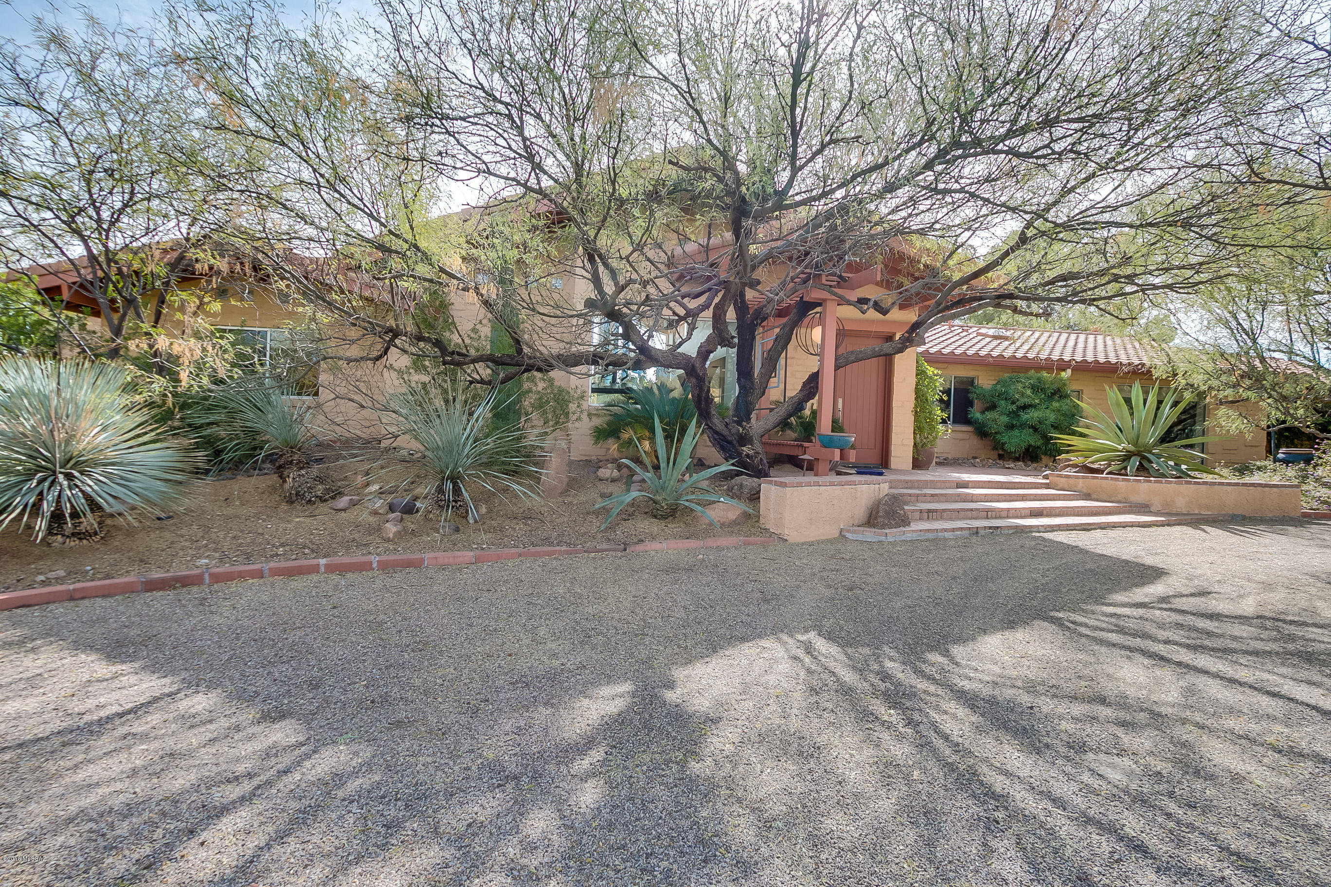 This is a one-of-a-kind gem on 2.56 acres in the heart of Green Valley. Totally remodeled from its 1973 plan and architecturally re-designed, this home is a stunner! With 23 ft ceilings in the living room and floor to ceiling fountain, recessed lighting, tall windows and a center wood-burning fireplace similar to one in a top resort in California, you'll be excited to call this home yours! There are 2 large suites plus an office/3rd bedroom. The huge master suite has lots of natural light from the windows that overlook the back patio and pool. The deluxe master bath features glass block walls, large ceramic tile floor, jetted tub, separate walk-in shower and marble counters on natural maple cabinets. The other suite is also huge and has a luxury bath with glass block walk-in shower, marble countertops and tile floor. There's also a large walk-in closet. The 3rd bedroom/office is designed as dual purpose. You can work at the built-in desk with a granite slab top and plenty of cabinets for your papers or turn it into a guest bedroom with an adjacent bathroom with shower. The kitchen area is designed for entertaining and comfort with large granite top island, eat-in area, and seating area with TV, maple cabinets and lots of windows that bring the outdoors in. From here you can walk outside to the patio and pool with a large stone waterfall giving your space the feel of tranquility and peace, an oasis in the desert! A separate open formal dining room with beamed ceiling, original adobe wall, large ceramic tile on the diagonal, and recessed lighting is there for your entertaining needs.
