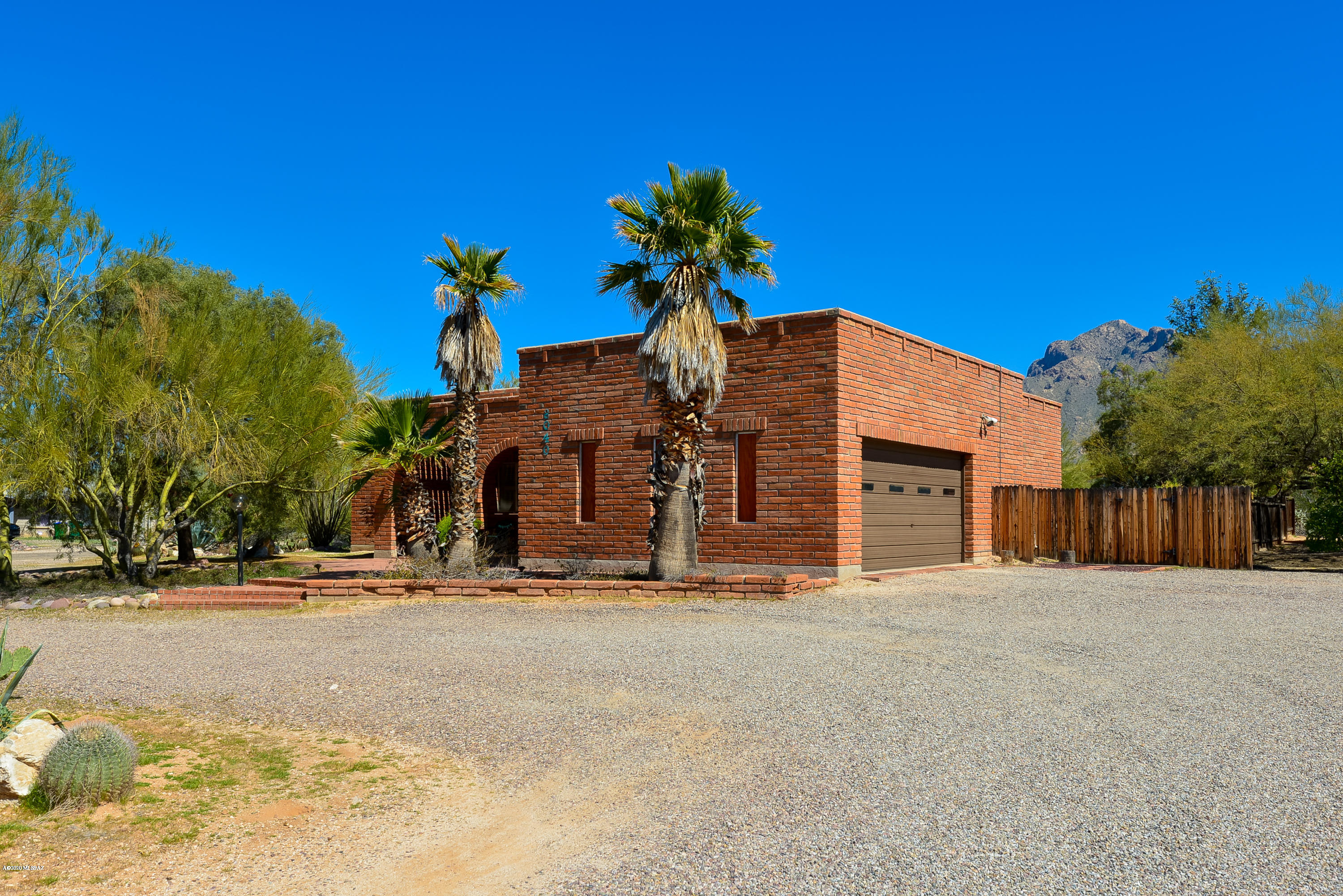 Seller to entertain/counter offers between $300k-$315k. Design your dream home in this timeless, burnt adobe home with many great elements to build upon! Situated on 3/4 acre, this property offers endless possibilities and plenty of lot space for extra parking or the addition of a pool, workshop, etc. Views of Pusch Ridge, mature shade trees, and an extended covered patio highlight the large backyard perfect for year-round outdoor living. Inside, a large living area is accented by lovely wood beams, beehive fireplace, and French doors leading to the backyard. A roomy kitchen offers classic charm or the opportunity to transform into your dream kitchen! Extra storage/workspace in the nearby laundry. Generously-sized owner's suite with French doors for private entry to the backyard. Near Tohono Chul Park, shopping/dining, parks, schools, and more!