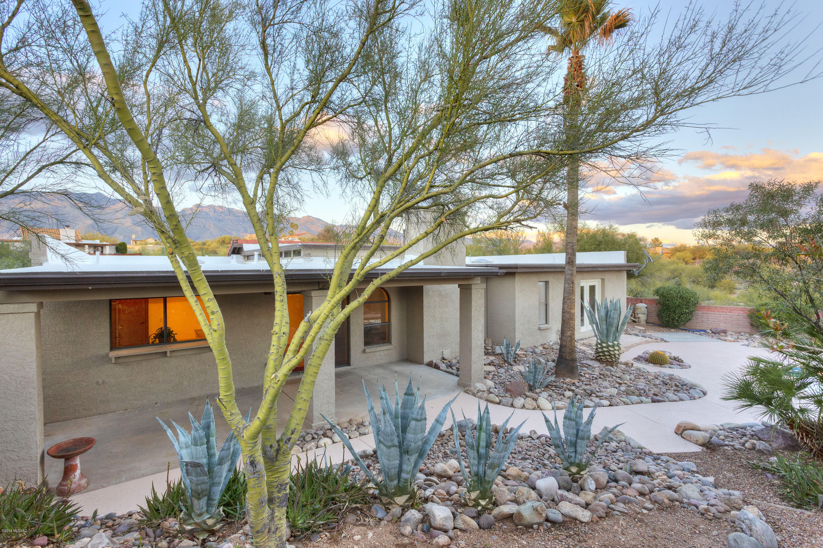 A Heatherwood Hills gem!  Welcome to your private ridge-top home with serene mountain and city views.  This home features warm saltillo tile in living areas, kitchen, hallways, and baths. Four bedrooms feature wood flooring, one of which would make a great den with its built-in bookshelves. The landscaped backyard, with mature trees and desert plants, welcomes you to enjoy time by the pool in the walled and private desert oasis. Master suite features it's own french doors to your backyard get-a-way as well.  Tile has been professionally cleaned and sealed. Pool decking was just cleaned and repainted. Pool is cleaned & maintained weekly.  Great location on nearly an acre.