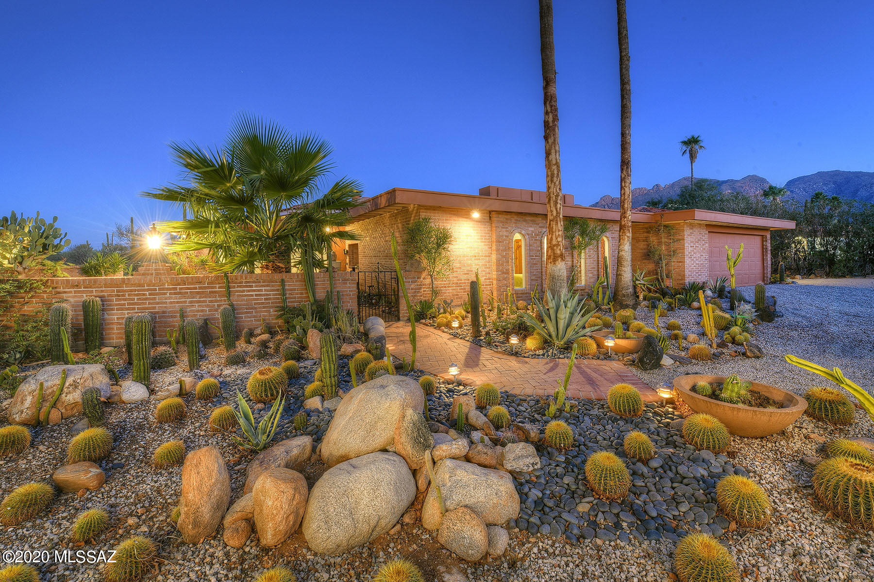 ''The House In the Round'' — this unique, 2,697 sq. ft. architecturally distinctive mid-century modern home is located on a .89-acre mountain view-lot in the Catalina Foothills. Enter the home through a lush vegetated courtyard and into the glass-entry foyer – bringing the outside garden in. Highlight of the 4-bedroom, 3-bath residence include all masonry construction, high ceilings, clerestory windows, 24'' x 24'' scored concrete flooring, unique room configurations, minimalist contemporary aesthetic, arched windows, a built-in bookshelves, and 3 wood-burning fireplaces. The gourmet kitchen, open to the great room, provides marble counters, stainless steel appliances and a pantry. The home offers a split bedroom floor plan with 2 master suites. Additional features include a 2-car gara
