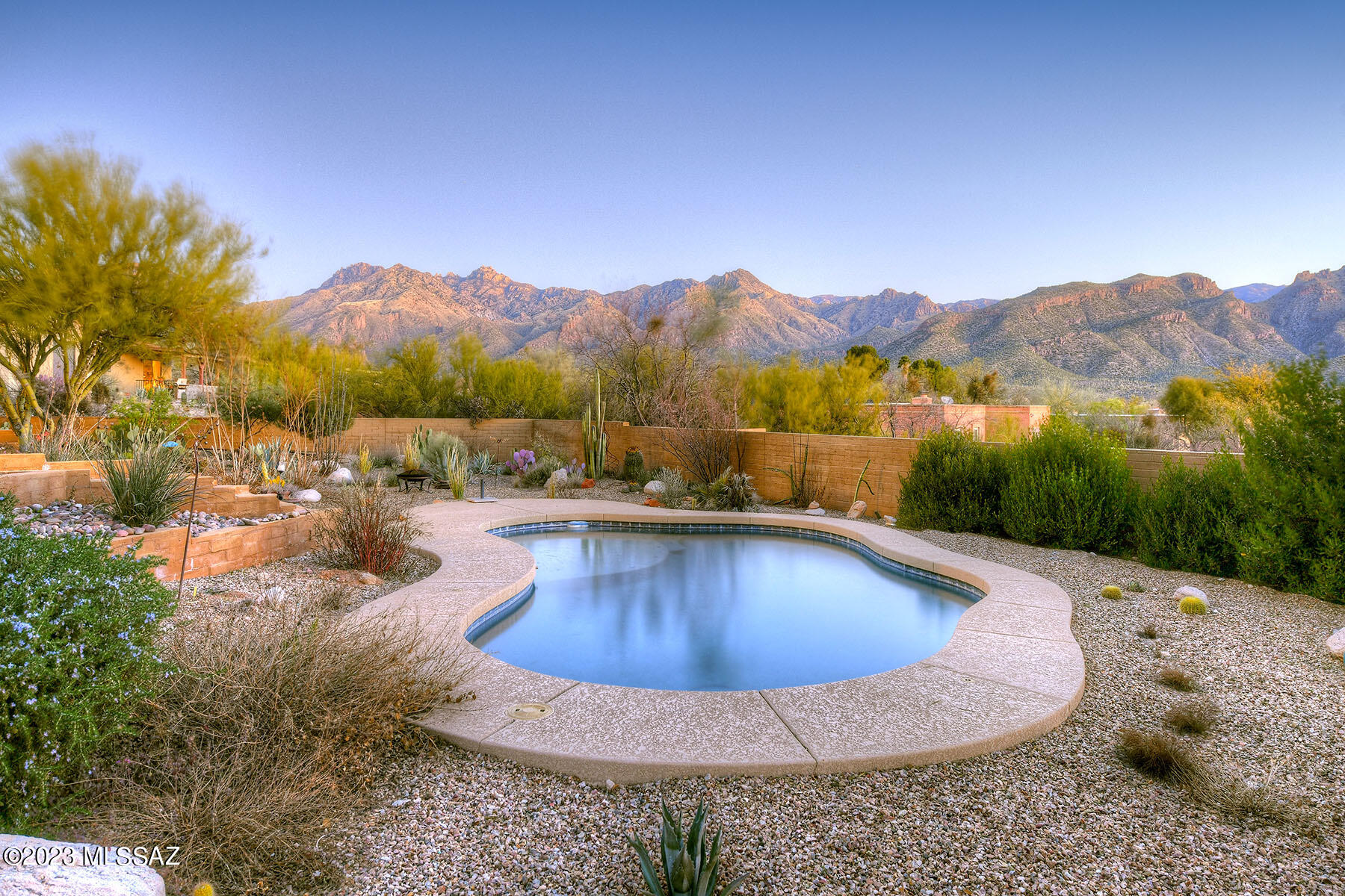 Hidden Valley Gem, offers immense views of the Santa Catalina & Rincon Mt ranges!  Beautifully updated 2237 sq ft home has an open and spacious living area, stacked stone fireplace, great room, kitchen & dining area.  Beautifully appointed Cook's kitchen has updated & ample custom cabinetry, breakfast bar, SS Appliances, Granite counters & large walk in pantry.  3 large bedrooms.  The primary bedroom has an ensuite updated bathroom w/double vanity, walk in shower, sliders to back porch.  The 2nd & 3rd bedrooms share an updated hall bathroom w/tub & shower, double vanity. Separate family room.  Newer HVAC system! Custom wrought iron entry door.  Covered patios both front and back yard.  Newer, heated,  Pebble Tec pool & pool equipment.  Very private and within walking distance to a private 12 acre riparian park that serves the Hidden Valley neighborhood.  Great for hiking, birding & all around nature lovers. Lovely desert landscape! Oversized 2 car garage with large storage area & tons of off street parking.