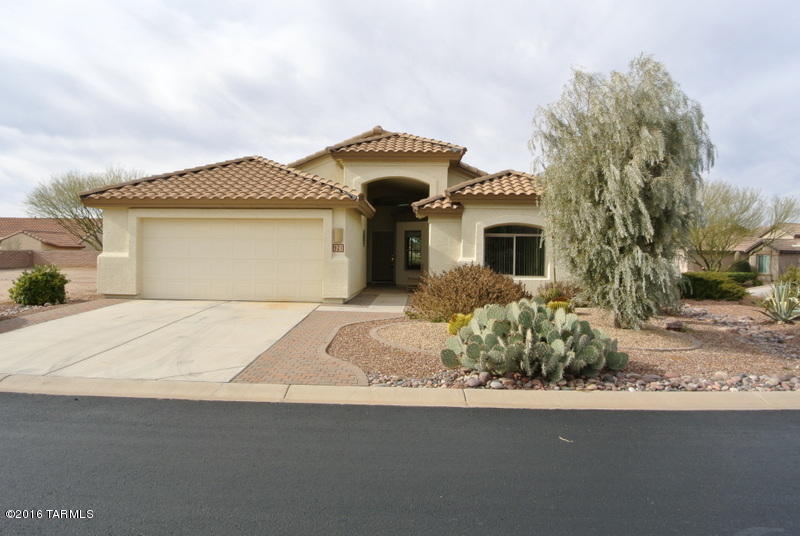 What a great value on this home! Located at the east end of the community, little traffic to drive by - the lot is high above the street so not to worry about privacy. Not many of these models come on the market so don't delay. Enjoy the large feeling of this home with a living room, family room, kitchen with a desk area and dining area. There is also a den and two bedrooms and two full baths. Landscaping is mature with great shade trees in the back. The entire home is ceramic tile, easy care marble counter tops in the bathrooms, dark maple cabinets with roll outs in the lower kitchen cabinets. The master suite has a door to the back patio and a luxurious soaking tub. Ceiling fans with lights in all rooms but the den. Yard is partially walled and even has a bit of ''grass''!