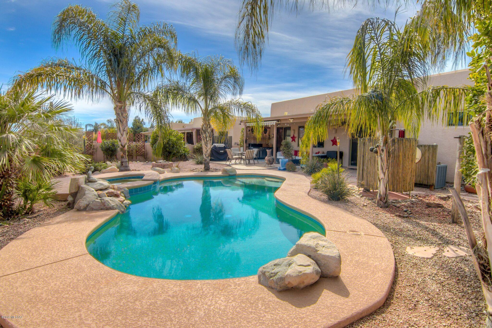 Beautiful Desert Oasis and Entertainer's Dream Home! 4/2 with large open concept kitchen/great room. Formal living and dining space features gas fireplace. 4th bedroom  with double doors would be ideal office, home gym or media room.  Large ceramic tile in neutral color palette throughout most of home, solid surface flooring in secondary bedrooms. Sparkling pool and spa are the stars of the professionally landscaped backyard and outdoor kitchen and shower add convenience and fun to an already amazing space. Sunsetter retractable awning helps shade the extended patio area in the warmer months. New gas stove, newer dishwasher,  built in microwave and LG refrigerator all Stainless Steel.  Fresh exterior paint.