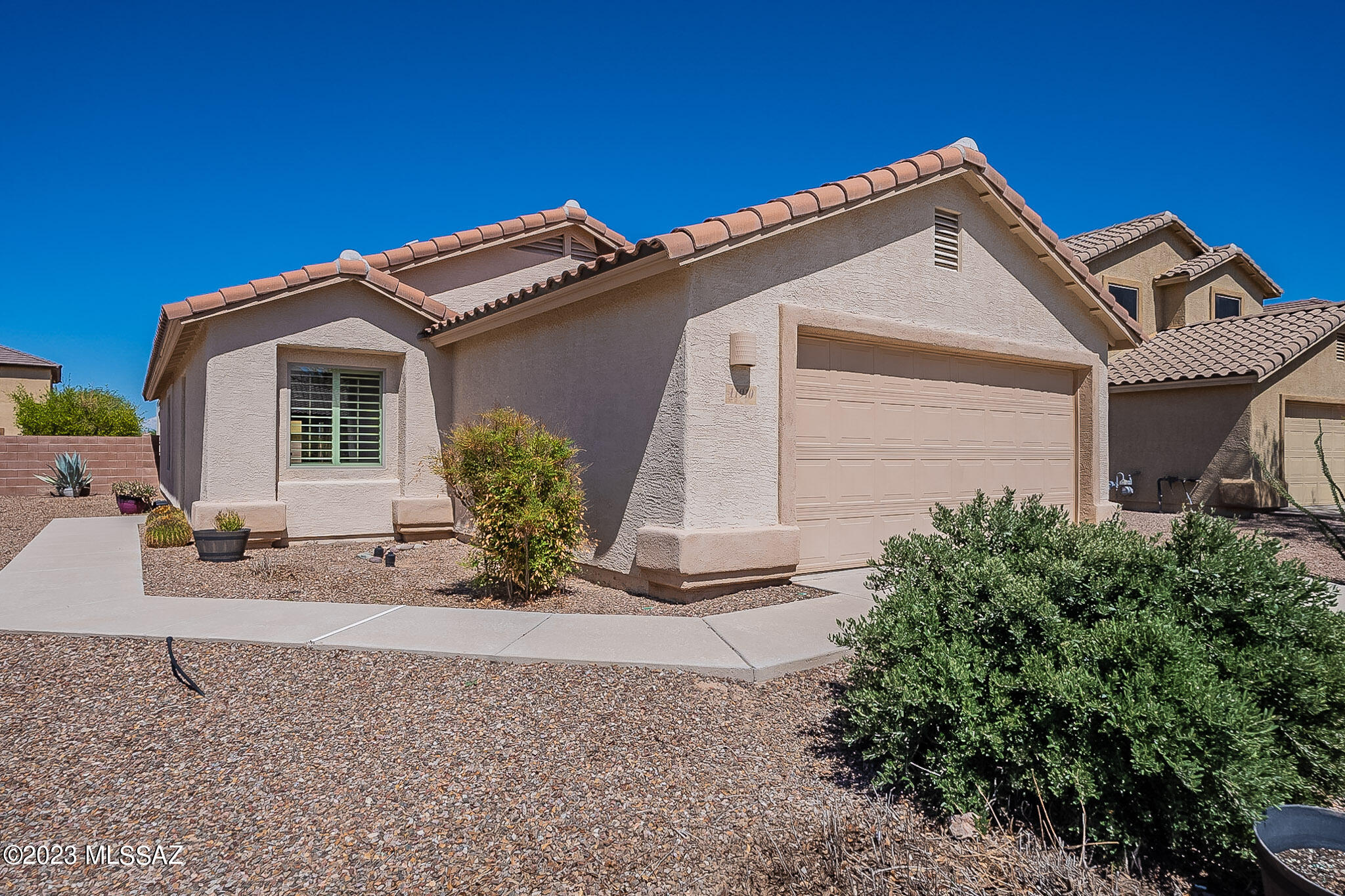 Welcome to an excellent home in wonderful Gladden Farms, a desirable community in West Tucson with neighborhood parks, planned walking/biking/jogging trails throughout, and excellent schools. Now available in this lovely community is a move-in ready home featuring fully owned solar panels that cut energy costs from thousands per year to almost nothing. Also note the new carpets and paint. The home provides a large north-facing rear yard with a covered patio with pavers and ample firepit for your enjoyment. With three bedrooms plus a great room and den, there is space for everyone. It's single story providing easy access to all rooms. The kitchen is a chef's delight with granite counters, a breakfast bar, microwave, gas range and dishwasher, plus ample cabinet space.. With plantation shutters throughout, this can be a very cozy and comfortable home. The primary bedroom provides a sitting area, a walk-in glass front shower and walk-in closet, with two additional bedrooms and a well-sized den nearby. The garage provides an epoxy floor, parking for two vehicles, plus water softener and utility sink for your convenience.  Notice the security screens on the front door. This home is clean and fresh, and ready to welcome its new owners!