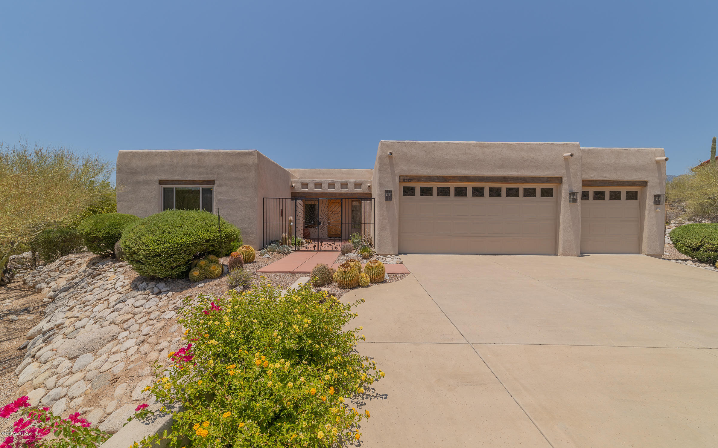 Immaculate three bedroom home in Summer Set. Enter through the custom wood front door to a spacious floor plan with high ceilings and a gas fireplace. The large open kitchen features granite counters and plenty of cabinets for storage. Master suite has a walk in closet, dual sinks,  a jetted tub plus a seperate walk in shower. Step outside to the covered back porch to take in the view of the Catalina Mountains or go for a swim in the pool. Pool and spa are heated with solar and propane. Solar panels are owned not leased. New roof installed and exterior of home painted in 2017. Interior recently repainted. Home also features a water purification system.