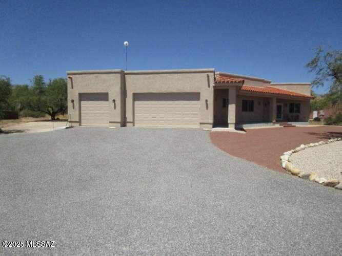 Custom 2017 Home on 1 Acre horse property Private setting in Tanque Verde Valley. Beautiful custom- built home offers blend of comfort, style, and tranquility, set far back from the main road. Sweeping mountain views and peace of country living. This ''like-new'' home features tile flooring throughout, attention to detail and quality craftsmanship. The chef inspired kitchen complete with gleaming granite countertops, self-closing cabinets, a convenient coffee bar, and a spacious pantry, stainless steel appliances, granite sinks that complement the modern design. Expansive great room with 11' ceilings and a custom designed fireplace. Elegant formal dining room with coffered ceiling. Master suite, oversized 3 car garage, southwestern shed, No HOA. Your new home awaits! Assumable financing