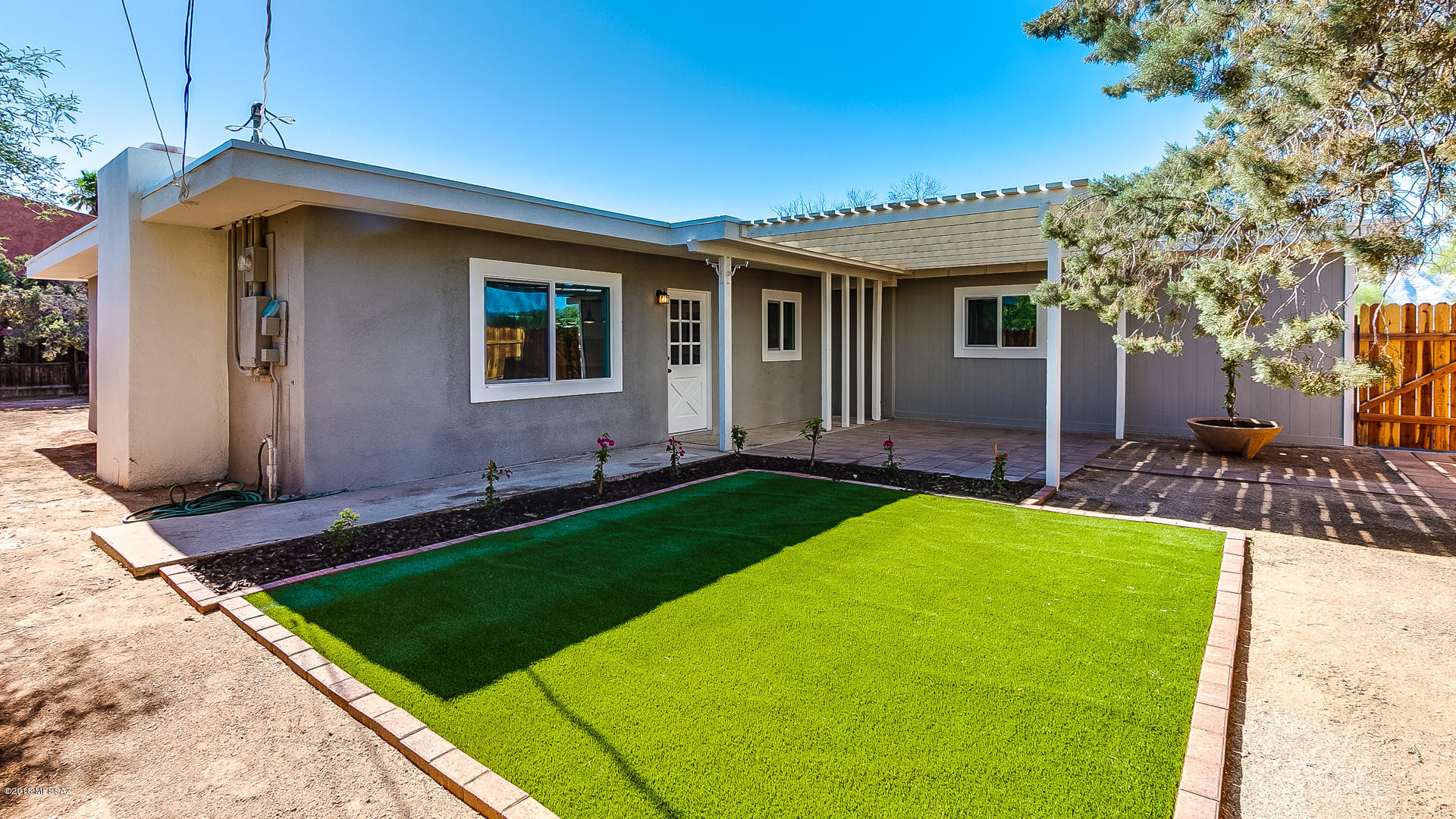 Absolutely stunning remodeled home in a convenient central location. Easy commute to U of A and downtown. Enter the freshly landscaped private courtyard through the secure gate and you will feel like you are in your own personal compound. Spacious lot and one car garage. When you enter the home you will be amazed at the high-end details this home offers. Large great room plan with generous island, remodeled kitchen with granite counter tops and pendant lighting. The great room is highlighted by custom concrete floors and a beautiful fireplace with a stunning engineered wood accent wall. All new bathrooms with custom tile surrounds and new fixtures. New water heater and heat pump. Don't let the Pima address fool you, this home sits east/west on the lot so minimal Pima exposure/road noise.