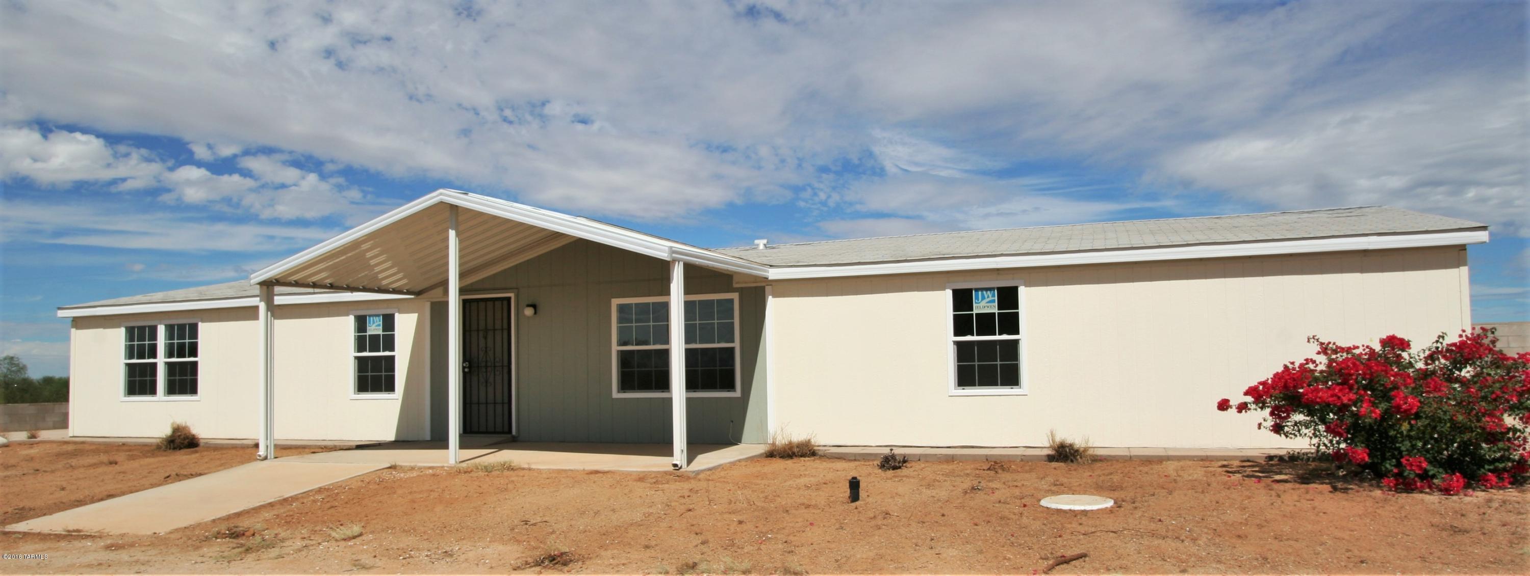 Great potential! Bring your RV, your horses and move right in and start
enjoying this great 4br 2 ba manufactured home on 4 acres! Owner has added new carpets, windows, trim,
counters, kitchen sink and faucet and hot water heater. Main living area has been modified to create a large,
inviting great room with a split bedroom floor plan. The property also features a large attached yard
surrounded by a block wall great for enjoying the views of Picacho Peak and an RV pad with hook-ups as well as
a poured pad for 2 car parking ready for an easy carport or even garage. Buy with peace of mind thanks to seller offering to purchase a home warranty for new owners!