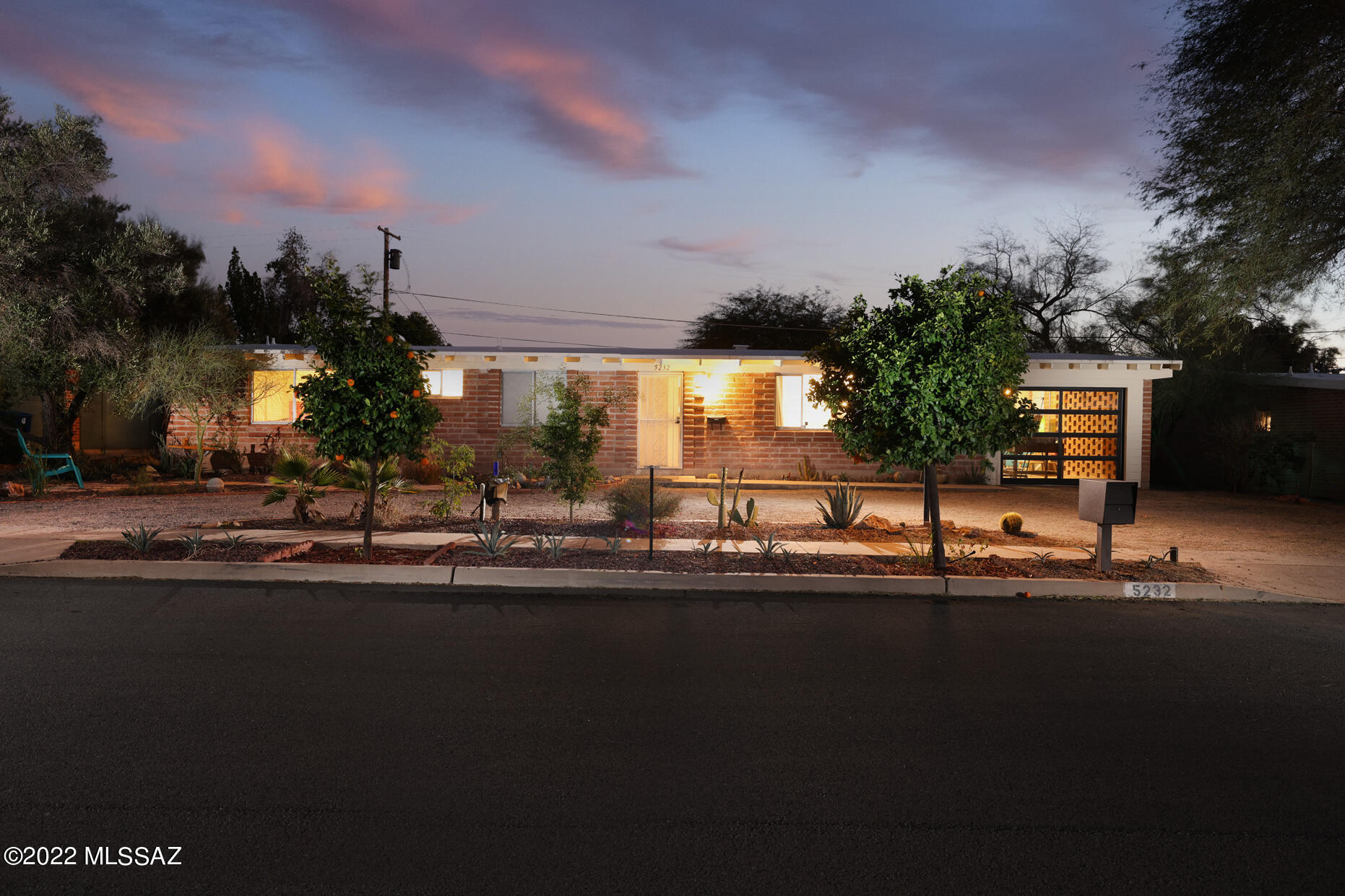 This centrally located home features concrete floors, vintage kitchen cabinets, wood-burning fireplace, and burnt adobe exterior walls. Master bathroom has been updated with classic deco floors, dual vanities, and a large, tiled shower. Enjoy the views of the Catalina Mountains from the living room windows! New HVAC system was installed a year ago. The home is located close to the UofA biking trail and is also very commutable to downtown and DMAFB. This home features a bonus room with a modern custom glass garage door and views of the Catalina Mountains. Bonus room can function as a garage, art studio, work at home office, or exercise room. One can enjoy evenings in a cozy private backyard sitting around a fire pit, surrounded by the fabulous Sonoran desert landscape!