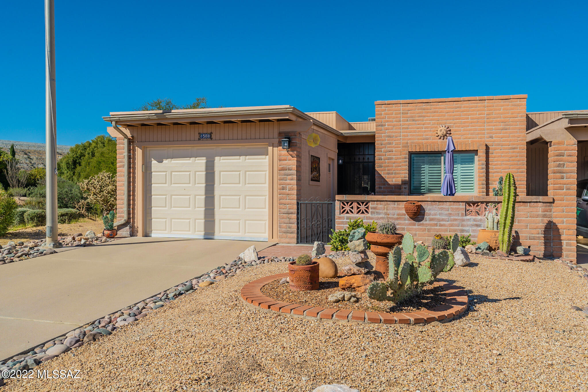 A terrific end-unit townhome with a desert common area to the west and mountain views from your cozy front courtyard!  Lovingly renovated from top to bottom including stylish grey kitchen cabinets with crown moldings; quartz countertops accented by artsy backsplash; stainless appliances and a stainless farmhouse sink under the view window. You'll appreciate the plank laminate flooring in the living room that makes cleaning a breeze.  The primary suite has a new executive-height vanity and an attractive glass door to the walk-in shower. The covered patio along with the extended paver patio provides places where you can unwind at the end of a busy day visiting with friends.  And, you'll have an enclosed garage space too!  A great location with plenty of privacy and great proximity to Canoa Trails Park and Desert Hills Recreation Center.  Cozy and quaint -   this home is ready for you to call it HOME!