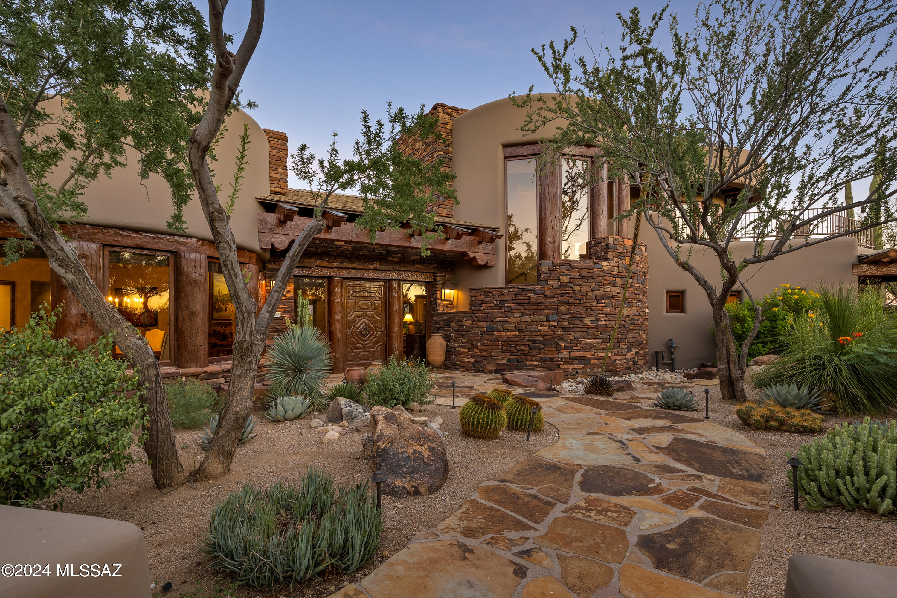 Indulge in the epitome of luxury living with this extraordinary residence situated within the confines of The Stone Canyon Golf Club development, where lush fairways and serene lake views seamlessly intertwine to create a haven of sophistication.
As you approach the estate, a sense of exclusivity unfolds with manicured landscape and an elegant facade hinting at the opulence within. Step through and appreciate high-end luxury and rustic charm welcomes you into a world of refined comfort and selections.
The heart of this home is a spacious great room adorned with Venetian plastered walls and ceilings, showcasing the craftsmanship of large rustic beams and corbels that lend an air of timeless elegance. Oversized windows frame captivating views of the manicure landscaping and the tranquil waters of the adjacent lake, blurring the lines between indoor and outdoor living.
Designed with top-of-the-line appliances, custom cabinetry, and an expansive center island. Whether you're hosting a formal dinner in the adjacent dining area or enjoying a casual meal in the breakfast nook, every culinary experience is elevated by the backdrop of picturesque surroundings.
Retreat to the master suite, a sanctuary of comfort and style. Vaulted ceilings, a private fireplace, and a spa-inspired ensuite where you have his & hers separate bathrooms to create an ambiance of indulgence. Each additional bedroom is a private retreat, offering panoramic views and luxurious finishes.
The allure of this home extends beyond its interiors. Step onto the outdoor terrace, where the al fresco living space beckons for relaxation and entertainment. Enjoy leisurely afternoons lounging by the fireplace or hosting gatherings in the eastern facing rear yard allowing the backdrop of the Catalina Mountains to frame the view while listening to the babbling brook that leads into the large pool and waterfall. This property transcends the ordinary, offering not just a residence but an elevated lifestyle. With direct access to the golf course and lake, you have the privilege of enjoying recreational activities just steps from your door. Immerse yourself in the exclusivity of this private golf club development, where luxury meets rustic charm in perfect harmony.
Seize the opportunity to own this exceptional property, where every detail, from the upper-level game room/media/room or additional guest suite contributes to an unparalleled living experience. Welcome to the pinnacle of golf course living, a retreat where luxury, nature, and rustic elegance converge seamlessly.