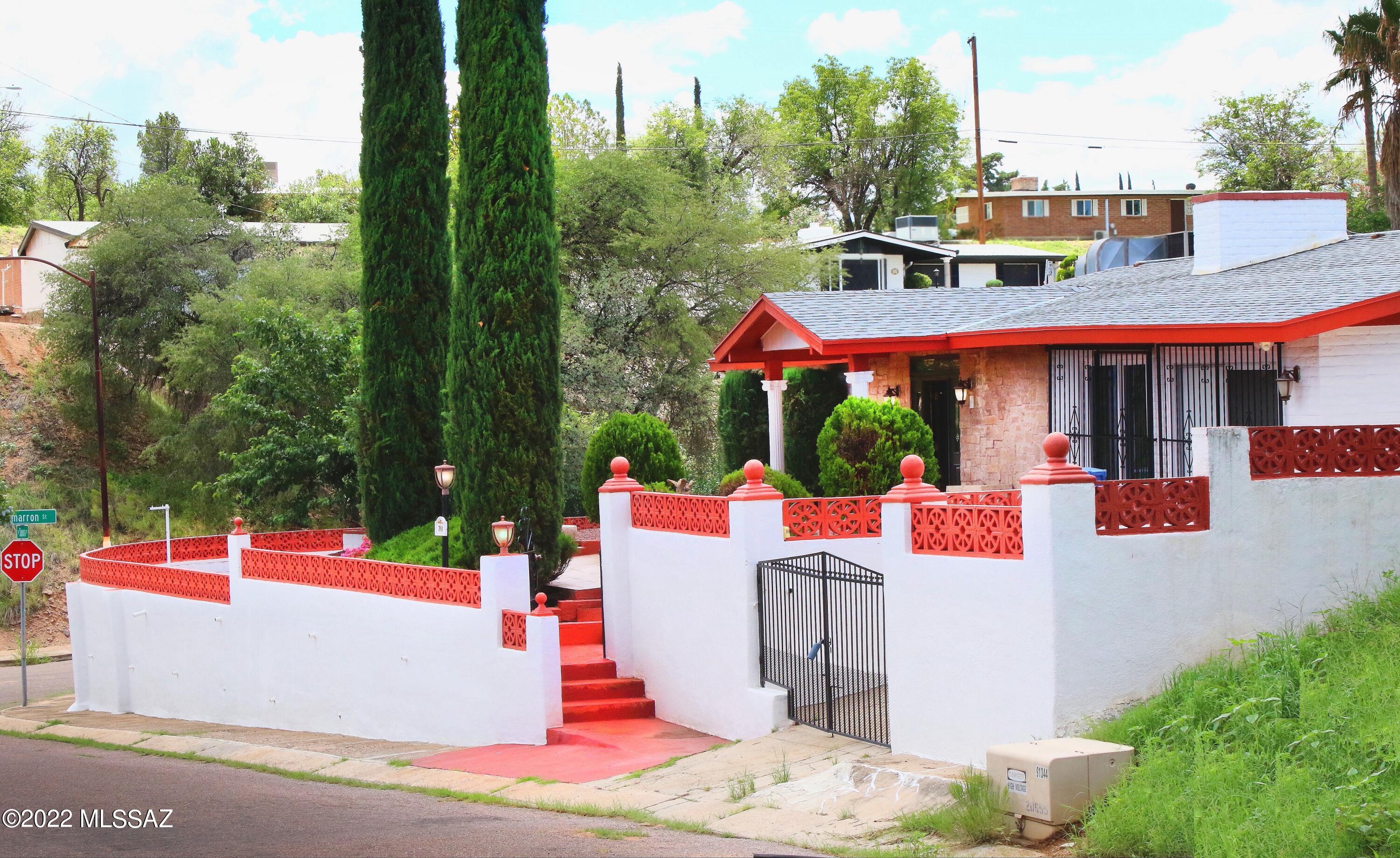 This four bedroom, two bath home is located in a quiet neighborhood in Midtown Nogales, and is close to shopping, services and schools. A new roof was installed in 2022, and the primary bathroom was remodeled.  New flooring was installed in all four bedrooms. The interior has been updated and includes a living room with wood burning fireplace, formal dining room, a large kitchen with plenty of cabinet space and countertops, a primary suite with walk-in closet and access to a front deck.  The home has  patio areas, a covered back deck, and a large yard with mature trees.