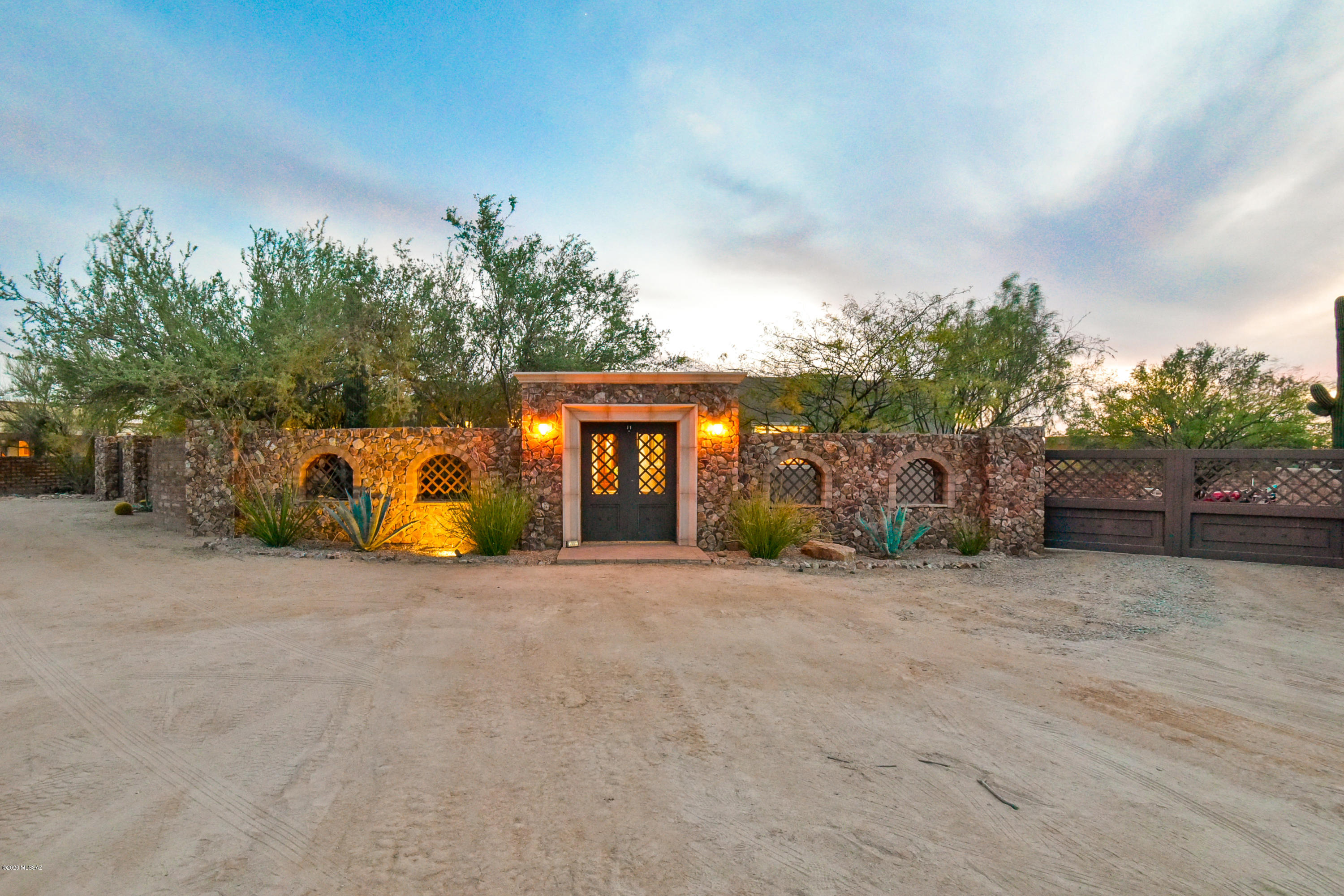 Walk up to this Stunning Stone Wall Entry Way with Custom Iron Gates to your Private Oasis in the Desert. Beautiful 3 Bedroom, 3 Bathroom Home on 1.01 Acres with large backyard that has a fully enclosed slump block masonry wall. Kitchen has Alder cabinets with Granite counter tops open to great room with beehive fireplace. Private Master Retreat with large walk-in closet with tons of upgrades. Detached 1 1/2 car garage with air-conditioned workshop. This home has it all!
