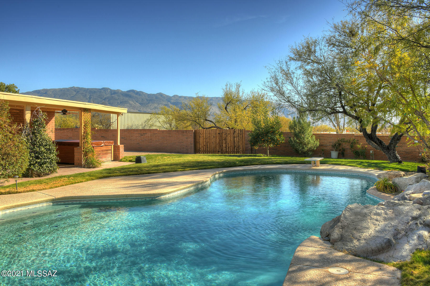 Charming home in Tanque Verde Valley located on a quiet cul-de-sac.  This previously 3 bedroom, is currently 2, (owner will replace wall if buyer prefers 3 bedroom). Bright updated kitchen with breakfast bar and nice sized eating area also opens to both a separate living and dining rooms. An extra large family room with a wood burning fireplace offers a spacious retreat for a recreation room or media room.  Master Suite has a walk-in tiled shower and a lovely view of the gorgeous backyard.  A covered porch in the back runs the length of the house with a hot tub for soaking and enjoying the views.  A sparkling pool with views of the Catalina Mountains is a great place to float the day away. Lots of extra space outside walled backyard for large toys or RV.  A Great Place to call Home!