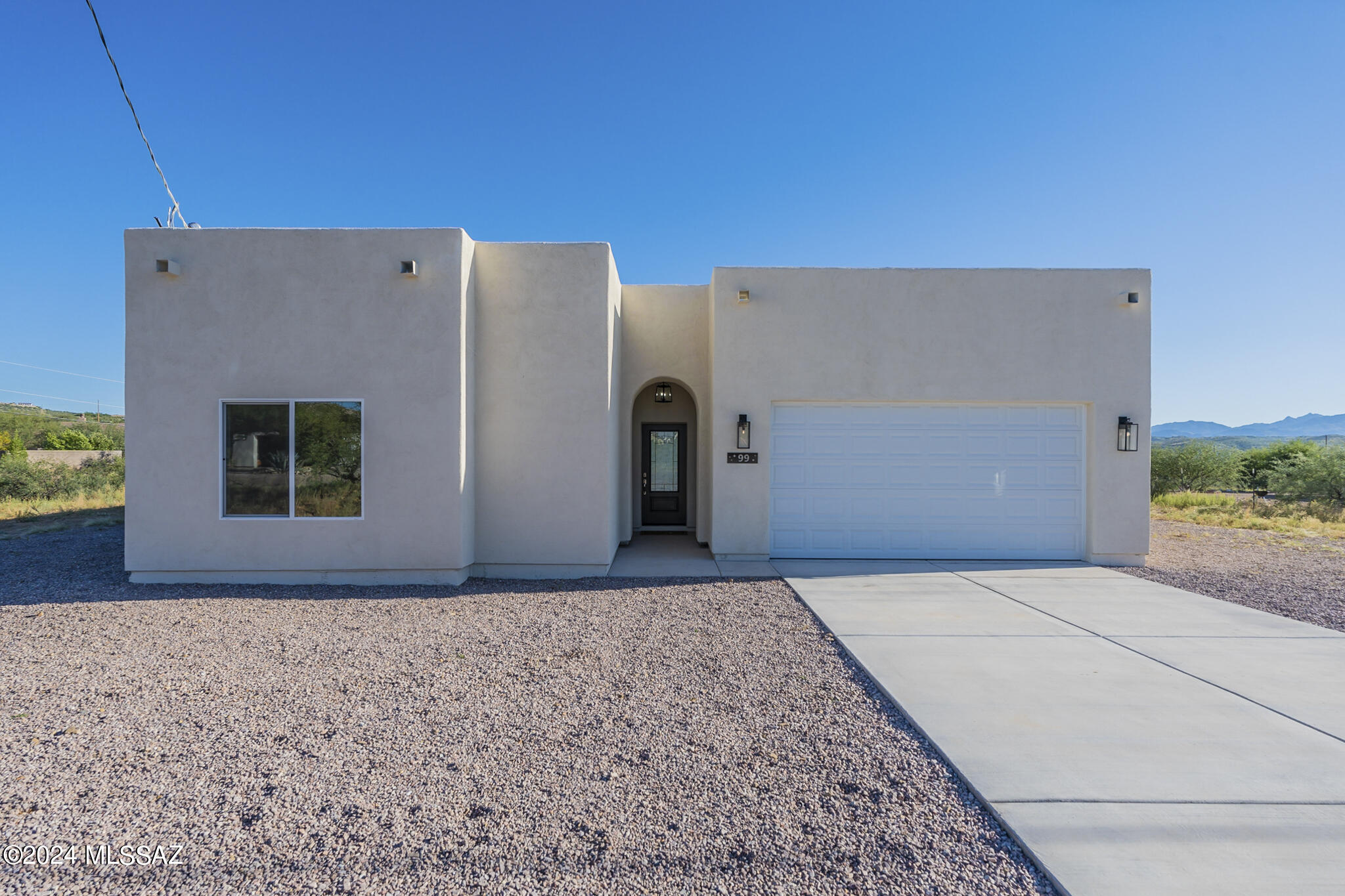 Embrace the tranquil Rio Rico lifestyle in this fabulous 3-bedroom, 2-bath home on over half an acre. Newly built and meticulously designed, this residence boasts captivating views of the San Cayetano and Tumacacori Mountains, providing dazzling sunsets year-round. Enjoy a well-appointed 1,793 sq ft floor plan with soaring 10-foot ceilings. Oversized dual-pane windows flood the home with sunlight. Gorgeous porcelain tile flooring, stainless steel appliances, and granite countertops throughout add a touch of luxury. The inviting open floor plan is perfect for family gatherings. A split floor plan ensures the privacy you desire. With nearby walking trails, mountain biking paths, and lakes, outdoor enthusiasts will find endless opportunities for adventure.  Click on video for a closer look.