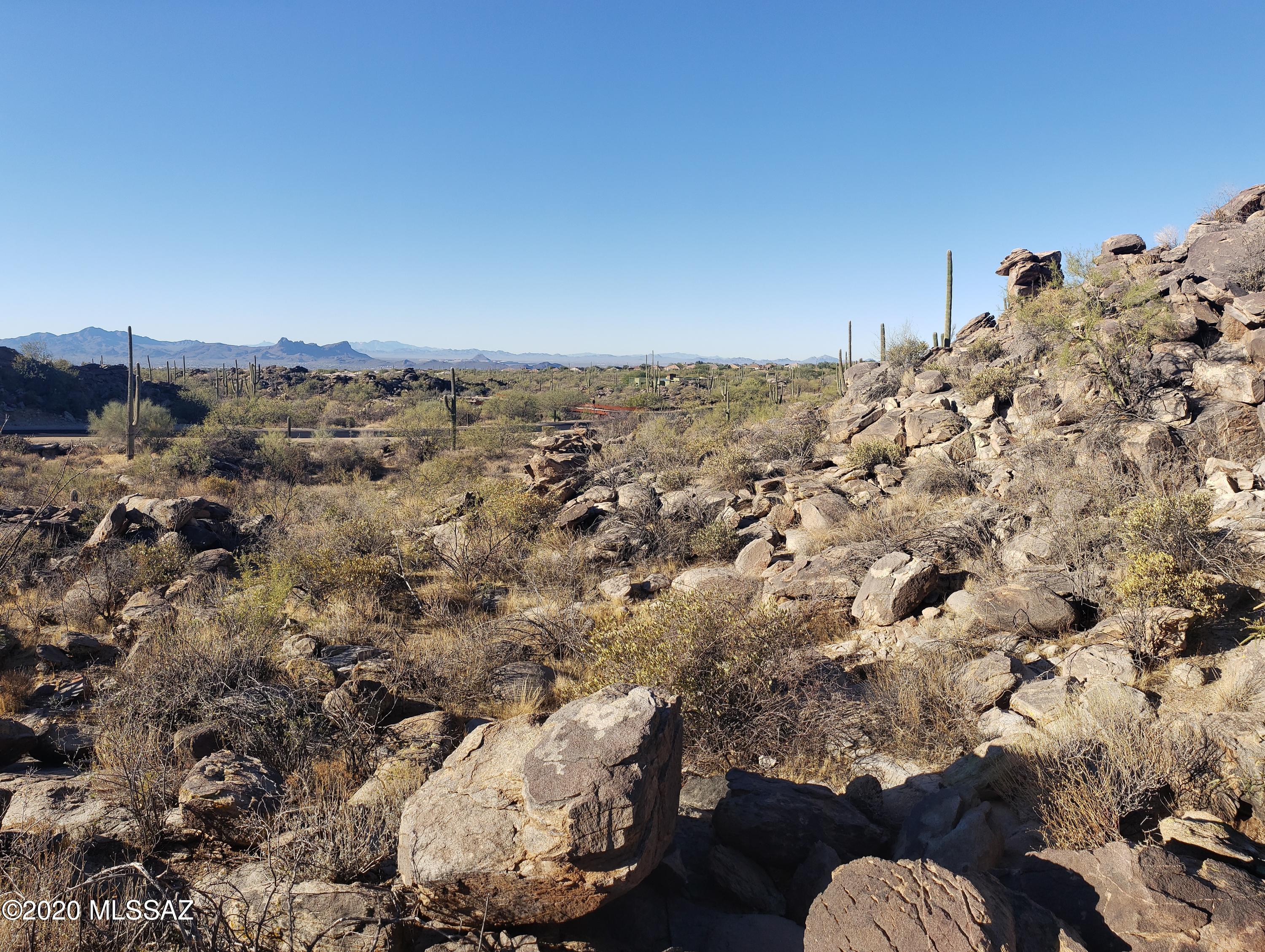 One of a handful of LONG-DISTANCE MOUNTAIN VIEW lots in Canyon Pass: a premiere gated community in NW Tucson area. Minimum house square footage is 2,500. Spectacular views of the TUCSON MOUNTAIN range to the west from a relatively flat building envelope. A small, but impressive looking boulder-laden hill in your back yard. Outstanding GOLF VENUES in the immediate area: The Gallery and the Ritz-Carlton Resort. The PREMIUM OUTLET MALL is located within a few miles of this community with many great shopping opportunities. You will have a front row seat to some of the most magnificent sunsets in the southwest.