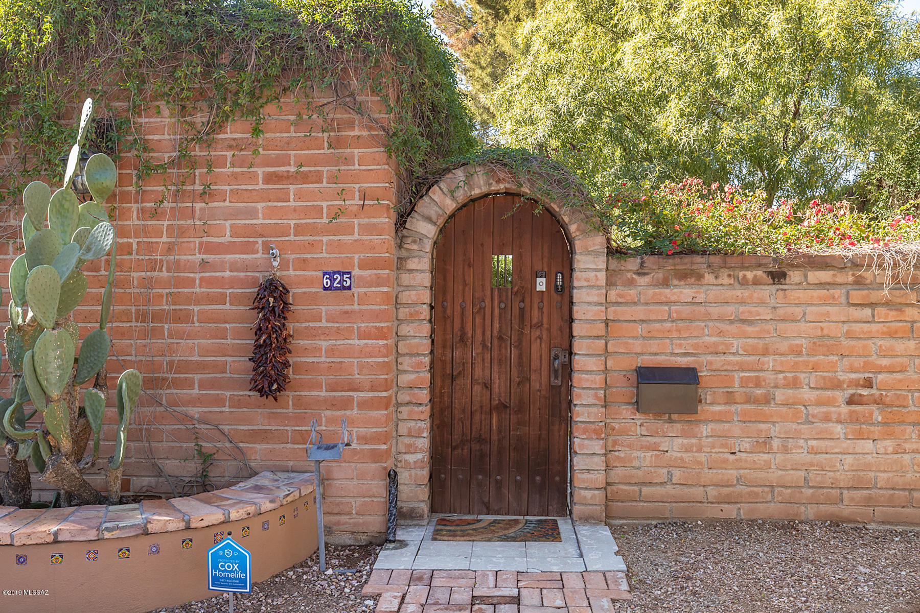 Charming burnt-adobe SAM HUGHES 4BR/3BA home.  Extremely private home w/gated entry courtyard.  Shady paved courtyard w/high walls, mature vegetation, fruit trees & classic fountain.  Living room is surrounded by beautiful arched entryways & cozy fireplace.  Updated kitchen w/quartz counters & stainless steel appliances including gas stove & double convection oven.  Master BR retreat has his/hers closets, 6 ft shower & private courtyard for morning coffee.  Family room bar has keg dispensing fridge.  Hard to find THREE-CAR GARAGE + WORKSHOP w/compressor & RV PARKING!!  Guest house w/private entrance ready for your guests, kids, or cash flow tenants.  Walk to Himmel Park/pool/playgrounds/library & Rincon Mkt.  Bike to  UA on 3rd ST protected bike path.