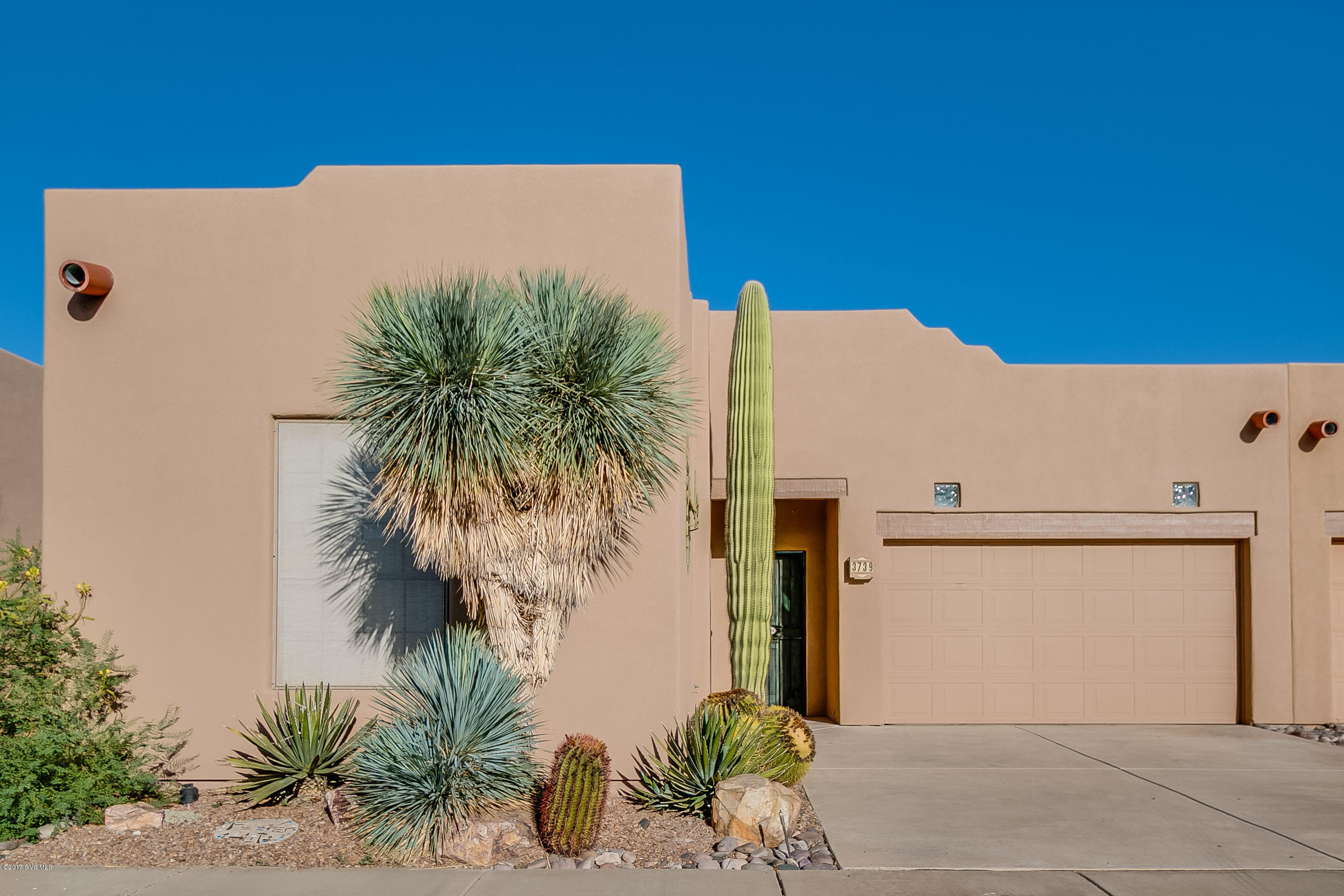 Southwestern parapet roof lines, a big old Saguaro cactus and low maintenance desert landscaping are the first things you will notice of the charming town home. Enter into the foyer and experience the ceramic floor tile that runs throughout this home to make it super easy care. The popular great room floor plan incorporates a quaint dining area and cozy living area that's drenched in views through a large 3-pane sliding door. The simple kitchen design makes entertaining easy with its convenient serving bar. The extra roomy master bedroom suite extends into a bathroom with an elongated vanity and sliding door shower enclosure. And, your guest bedroom, with its built-in pull-down Murphy bed will serve double time while it is used as your office. But, the best has yet to come as you  stroll out to the backyard with its extended red brick patio surrounded by lush green landscaping and common area open space for added privacy. Sit back and enjoy the Santa Rita mountain peaks emerging over the neighborhood roof tops. Or perhaps take a leisurely walk on the community walking trail or down to the recreation center for a work-our or a refreshing swim!