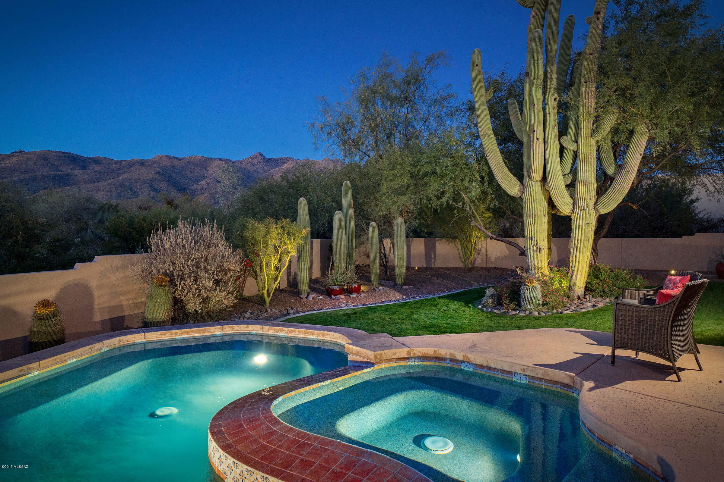 Beautiful Santa Fe home, 3 BR plus Den/3 Baths, with gorgeous mountain views. The great room has wood and log viga ceiling, kiva fireplace and a wall of windows looking out to the Catalina Mountains. Large master bedroom w/French doors leading to covered patio, Pool & Spa.  Master bath has dual sinks, garden tub, walk-in shower and large walk-in closet. Split bedroom plan. Kitchen has eat-in casual dining area, Stainless Steel appliances, rolling island and door to the north-facing patio.  Pool/spa was added in 2011.  The beautifully landscaped backyard is completely enclosed and features spectacular saguaro cactus & green grass.  3-car garage. All this and privacy on almost an acre in a gated community w/low HOA.