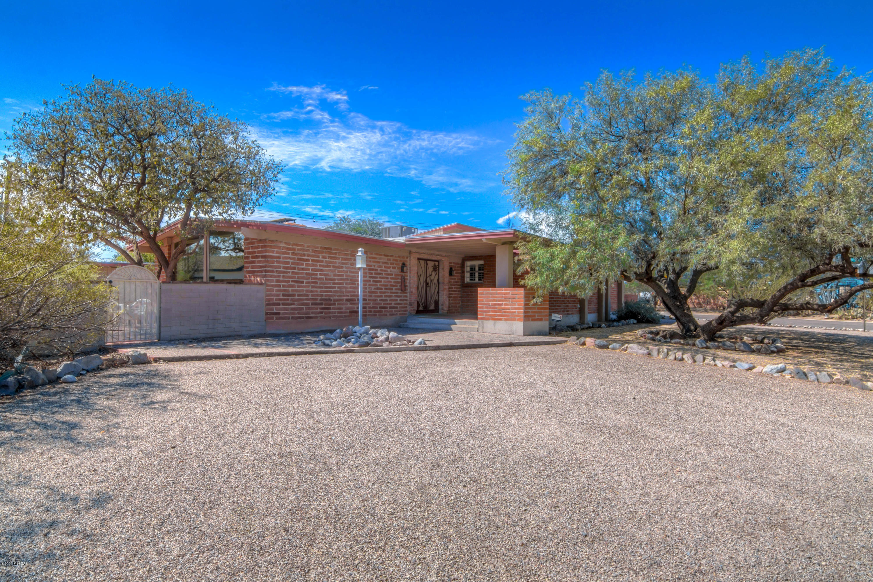 Mid century Central home on large corner lot in historic Highland Vista! Main house has two bedrooms (one of which has a separate entrance and parking area), two bathrooms with large great room, plenty of light and great floorplan! Newer triple pane Pella windows help with electric costs. Courtyard separates main house from studio guest house which could be used for so many things.... rental or multi-generational living, or office with separate entrance. Low care gorgeous yards, front and back with mature trees. No required HOA. Two blocks away is the Highland Vista neighborhood park and pool. Membership to this pool and the neighborhood association is optional; check out https://www.hvnatucson.org/ for more info. Don't miss out on this rare find!