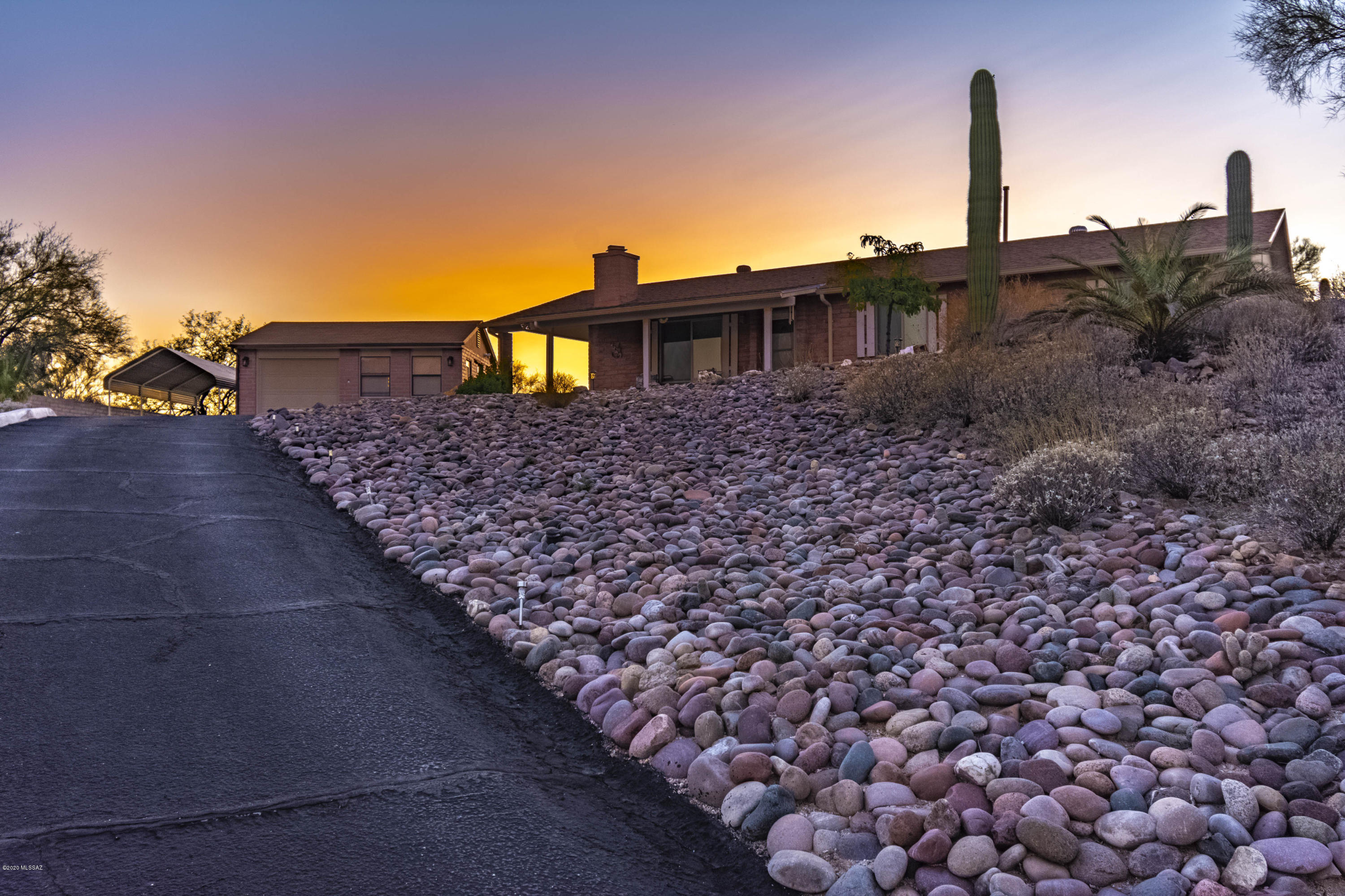 Unbelievable mountain & city views on top of the hill with long private drive/paved. Separate garage with nice workshop. Slump block construction 3 bedroom 2 bath home, greenhouse and 2 carports. Covered front porch all on 1.26 acre lot with over 40 Saguaro cacti on the lot. End of cul-de-sac property in Oro Valley with no HOA. RV parking allowed. Convenient to major shopping, restaurants, golf courses and Oro Valley Community Center. Call for a private showing.