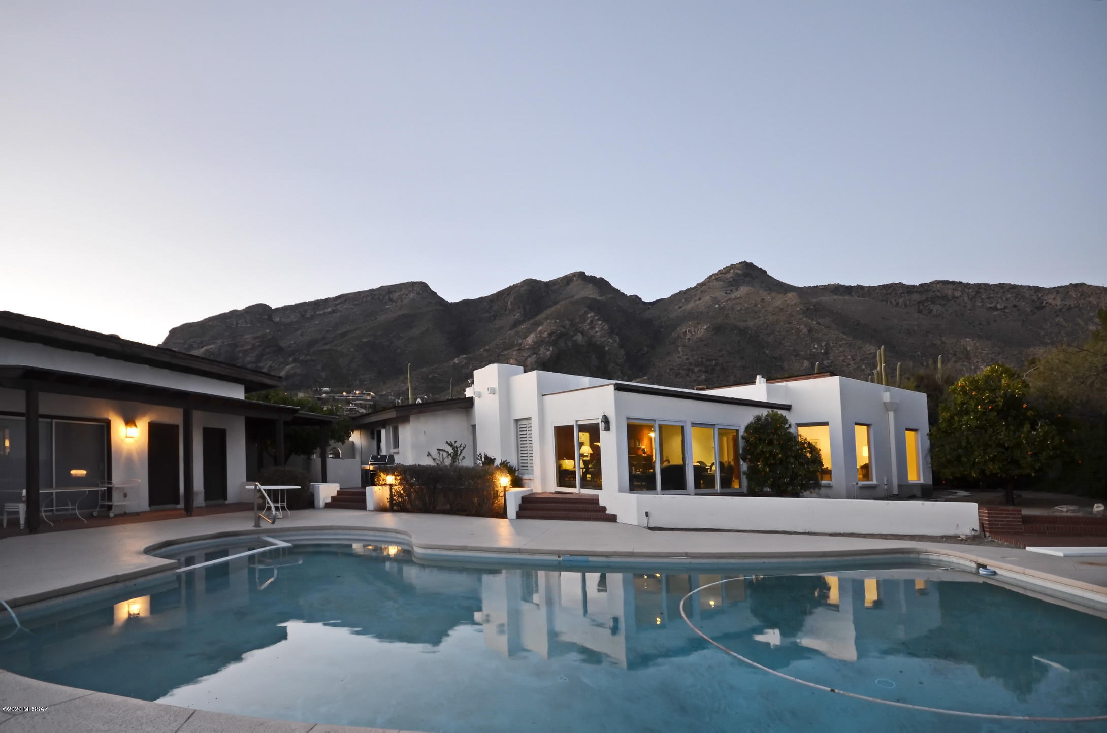 Panoramic city and mountain views from one of the most spectacular home sites in Tucson.  High above the Tucson valley lights, located on one of Skyline Country Club's most desired lots, this Fraker built masonry stucco home boasts over 4000 square feet of living space between the main residence and the guest quarters. Golf course lot. Priced to allow for updating.