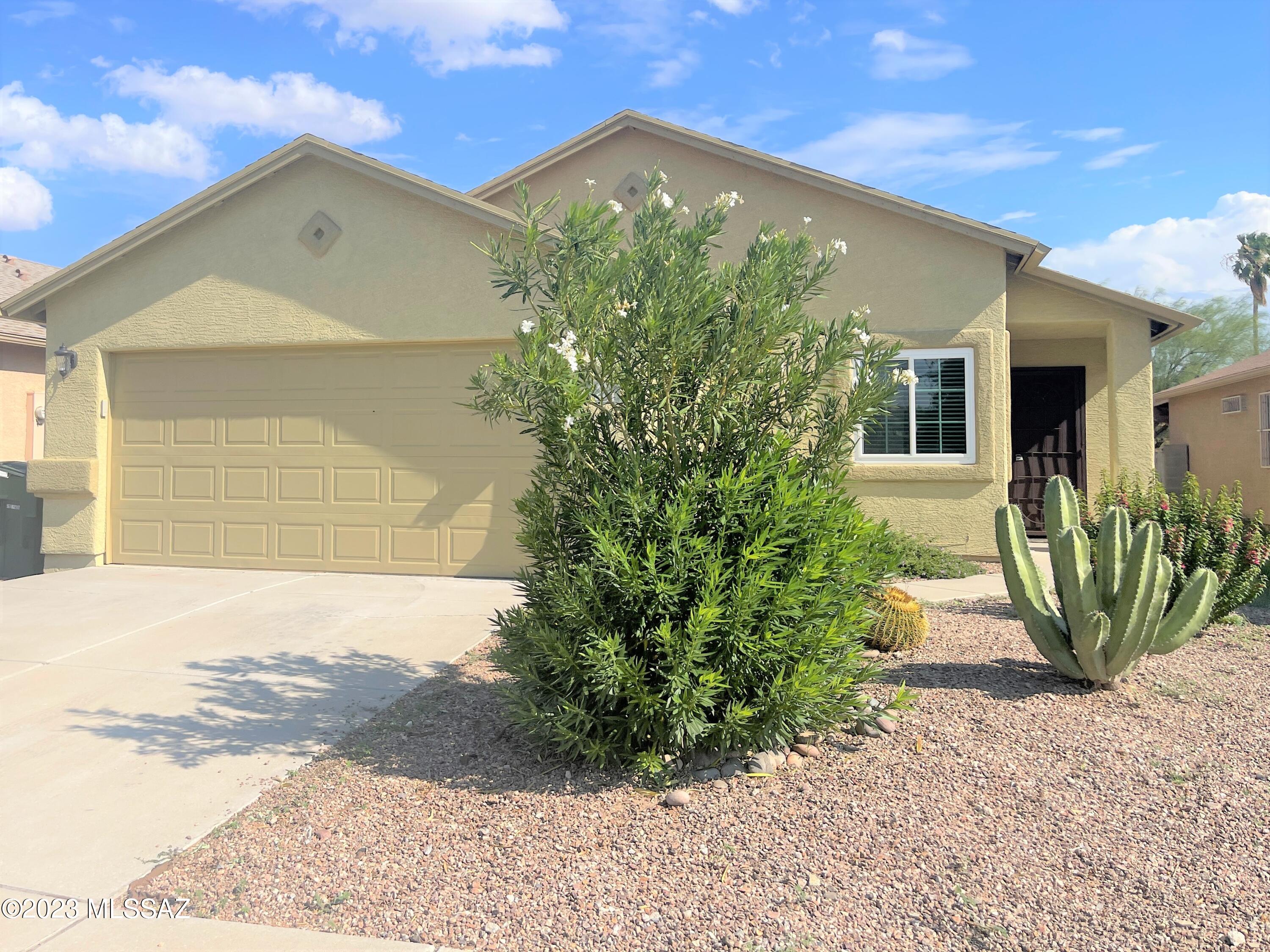 No Application Fees!  Remodeled 4 bedroom 2 bathroom single level Tucson home located on Midvale Terrace. This beautiful home has a number of upgrades including wood laminate flooring throughout with no carpeting, neutral paint throughout, upgraded fixtures and window blinds and doors, large open living room and separate family room.  Beautiful kitchen features quartz countertops, tile backsplash, separate pantry, upgraded island, ceramic top electric range, dishwasher and refrigerator. Split level floor plan with large primary suite including walk-in closet and remodeled bathroom with upgraded vanity and tiled shower. Three additional bedrooms on the opposite side of the home. Washing machine and dryer included and two car garage offers plenty of parking and storage.