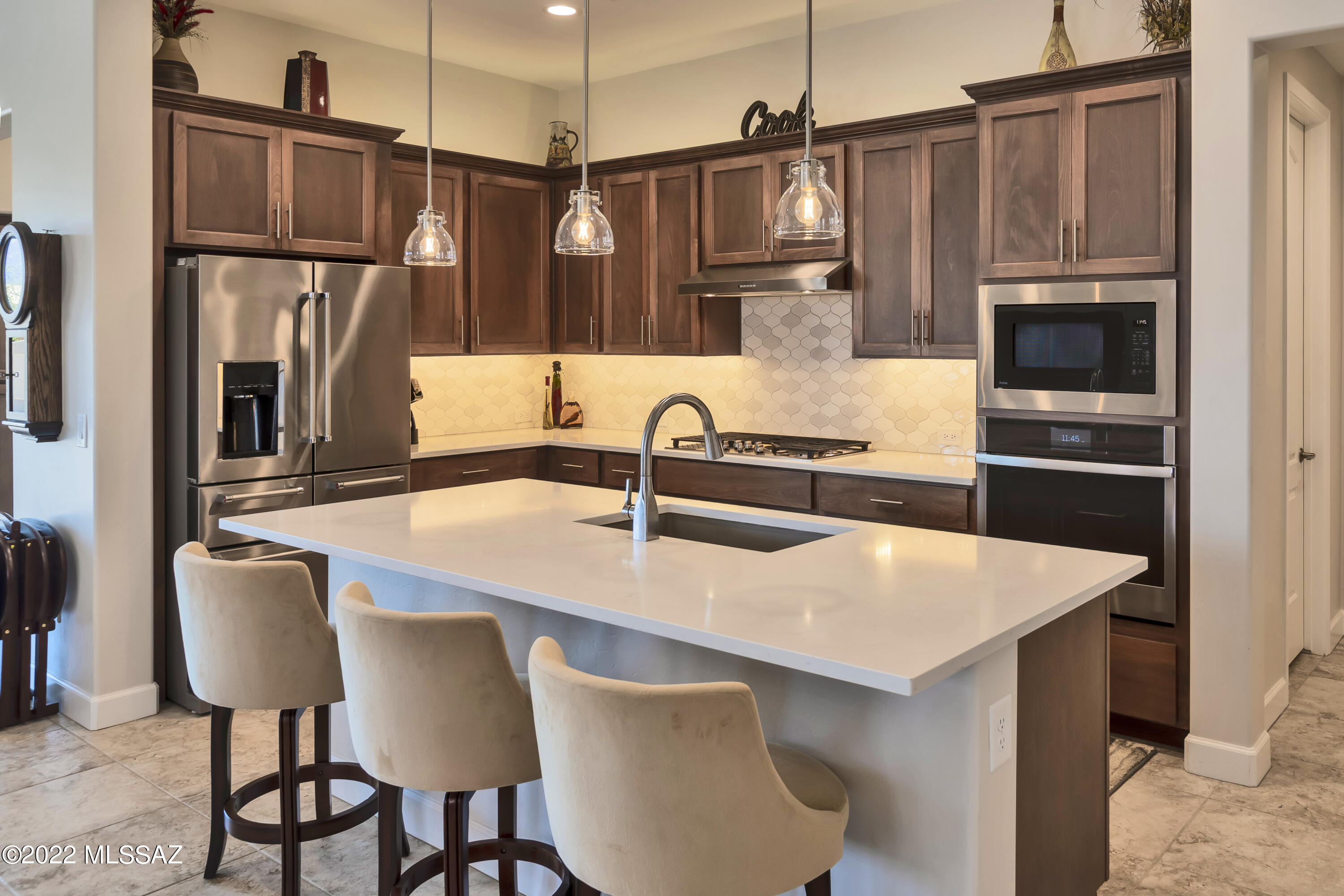 This very desirable Bella model, completed in 2020, is the perfect home for entertaining and enjoying the desert lifestyle. Step inside and be captivated by the bright, beautiful design. Gourmet kitchen has a beautiful tile backsplash, quartz countertops and gas cooktop. Upgraded light fixtures and ceiling fans throughout. Split floor plan offers privacy so your guests can enjoy a private en-suite. The spacious den is perfect for a home office, craft room or library. Private owner's suite has a gorgeous mountain view, en-suite bath with walk in shower, double sinks and vanity, upgraded carpet and a huge walk-in closet. Enjoy the morning sunrise and mountain view from your covered paver patio, complete with rolling shades. Garage has 3rd golf car garage and epoxy floor for easy maintenance. Now is the time start living your dream.