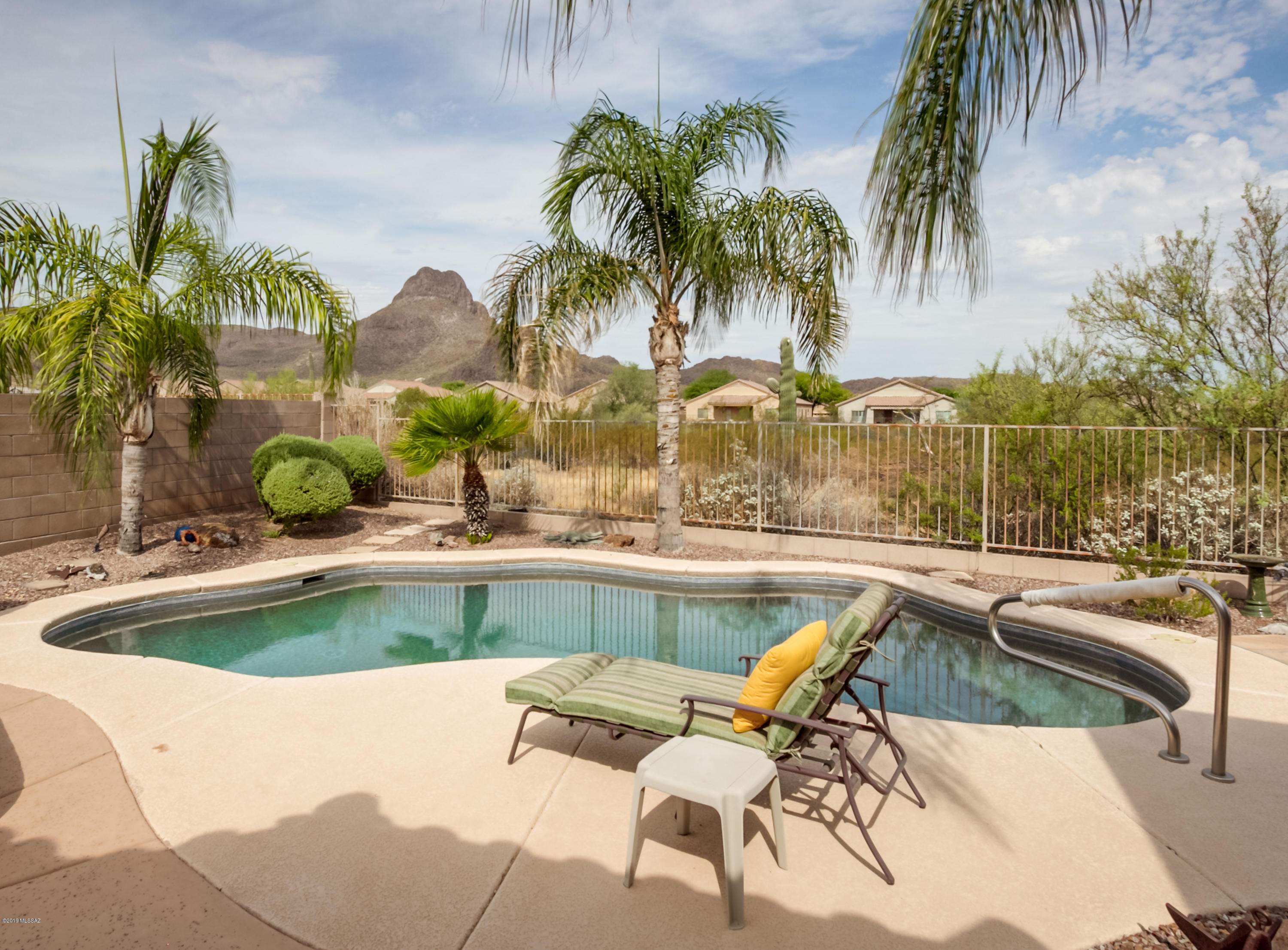 Views, Views, Views! Step outside into your backyard oasis, enveloped in the shadow of Sombrero Peak. Float in your sparkling pool, sipping a cool drink while watching the sunset. It's the perfect summer night's dream! And in winter, relax in your personal spa for sunsets enjoying the abundance of wildlife beyond your viewing fence. The beautifully landscaped yard with flagstone throughout, boasts citrus and palm tress, a BBQ area and an extended covered patio. Then enter into the heart of the home, the Greatroom, entertainment center for family/friends to gather by the fireplace, and always in view of the chef. The wall of windows brings in the outside scenic wonders. The updated kitchen w/granite counters and tall alderwood cabinets is a joy to work in. Ceramic neutral tile flows throughout this home with it's 4 bdrms/den. Surround sound fills the air with music of your choice. It's a must see! Come and make it your own desert paradise!