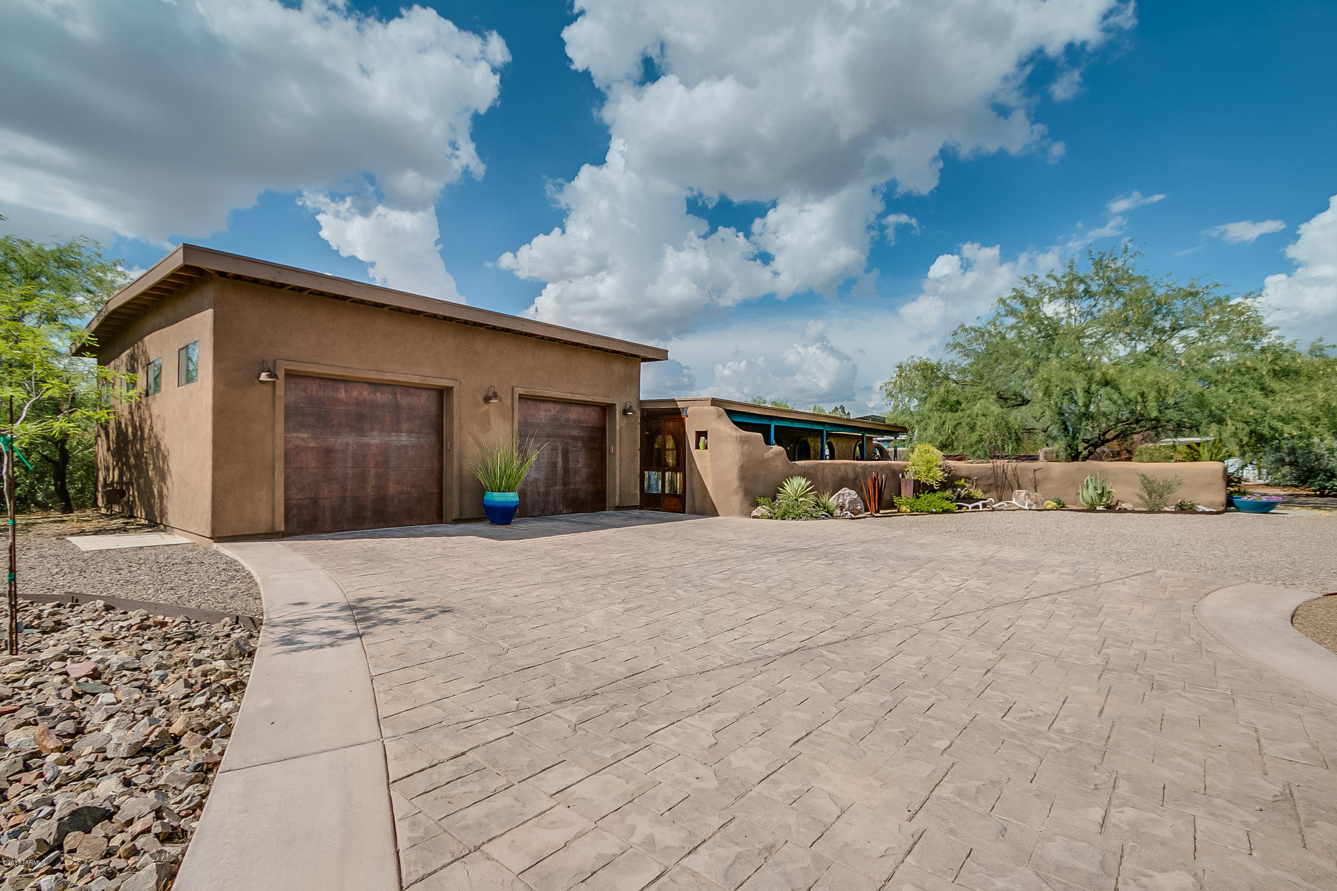 Get ready to be WOW'd with the custom details of this charming, totally remodeled home! This unique home features low maintenance stained concrete floors throughout the open floor plan. The great room has a custom built-in media center and the chef kitchen boasts granite counter tops, stainless steel appliances and extra storage. The master suite is spacious with its own access to the back patio, and walk-in closet with built in shelving and drawers. The master bath features a dual head shower, spa body spray and boulder for sitting. The over-sized 2 car garage has 12 foot ceilings with evap cooling. If you enjoy outdoor living, you will love the 1,200 sqft covered patio with stained concrete floors, built-in kitchen, wood fire pizza oven and hot tub. The backyard is beautifully landscaped landscaped with boulders, decorative metal and faux grass for entertaining. Need room for your toys?  The enclosed side yard features 2 covered RV spaces and a nice sized workshop.